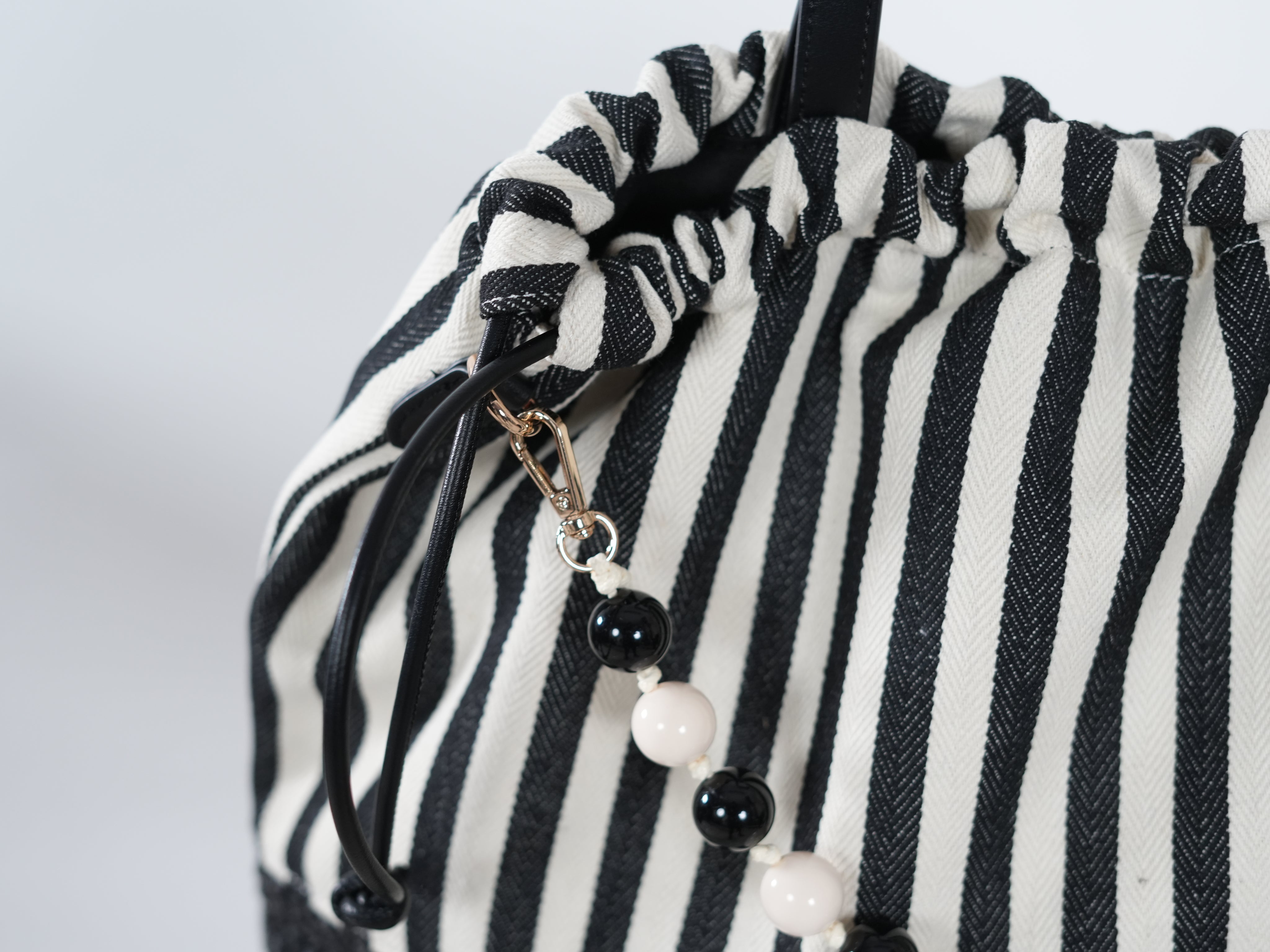 Gestreifte Tasche mit Perlenkette