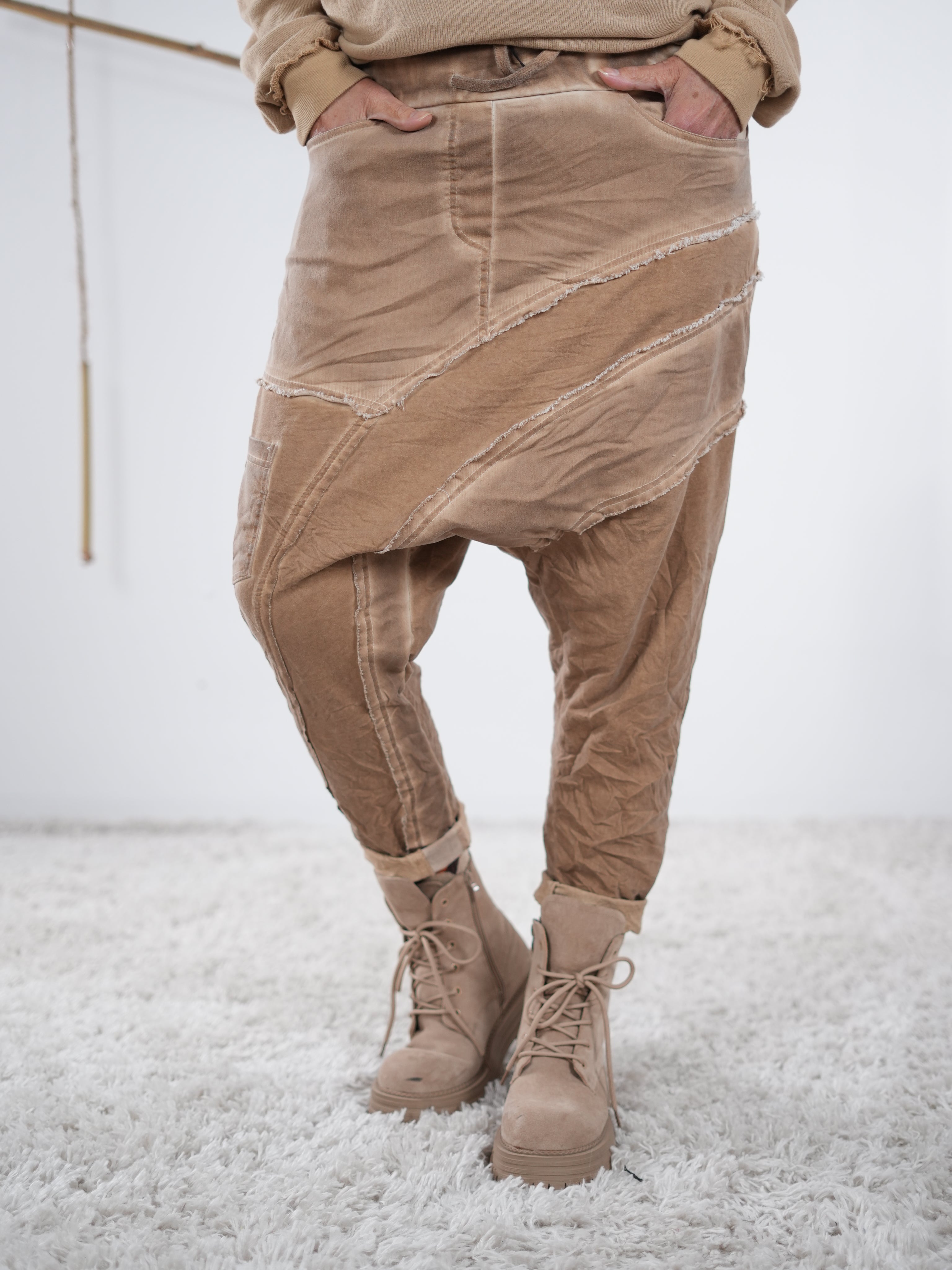 Baggyhose in Camel mit markanten Außennaht-Details und lockerem Schnitt, kombiniert mit beigefarbenen Boots.