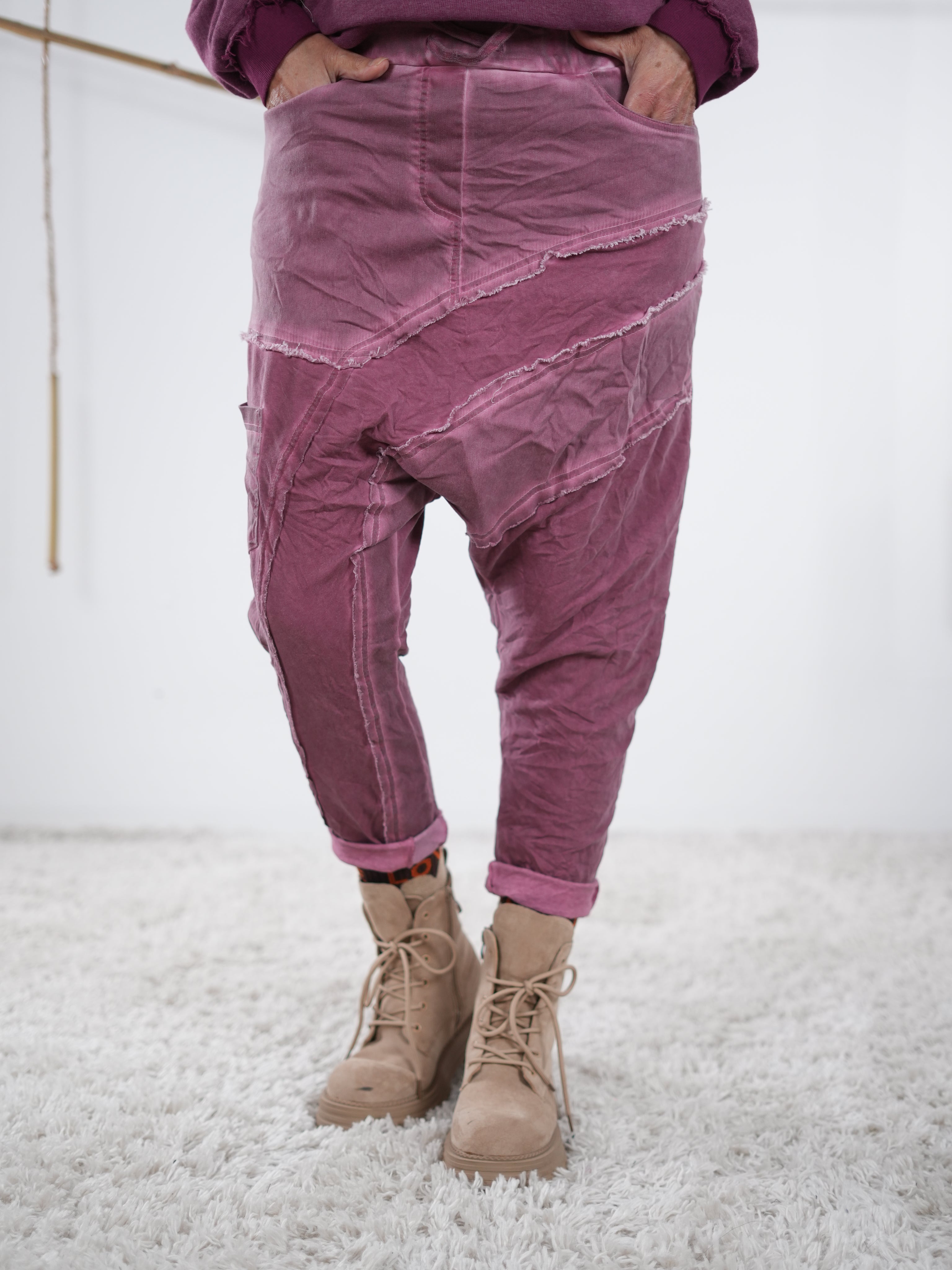 Baggyhose in Beerenton mit dekorativen Außennaht-Details und lockerem Schnitt, kombiniert mit Boots.