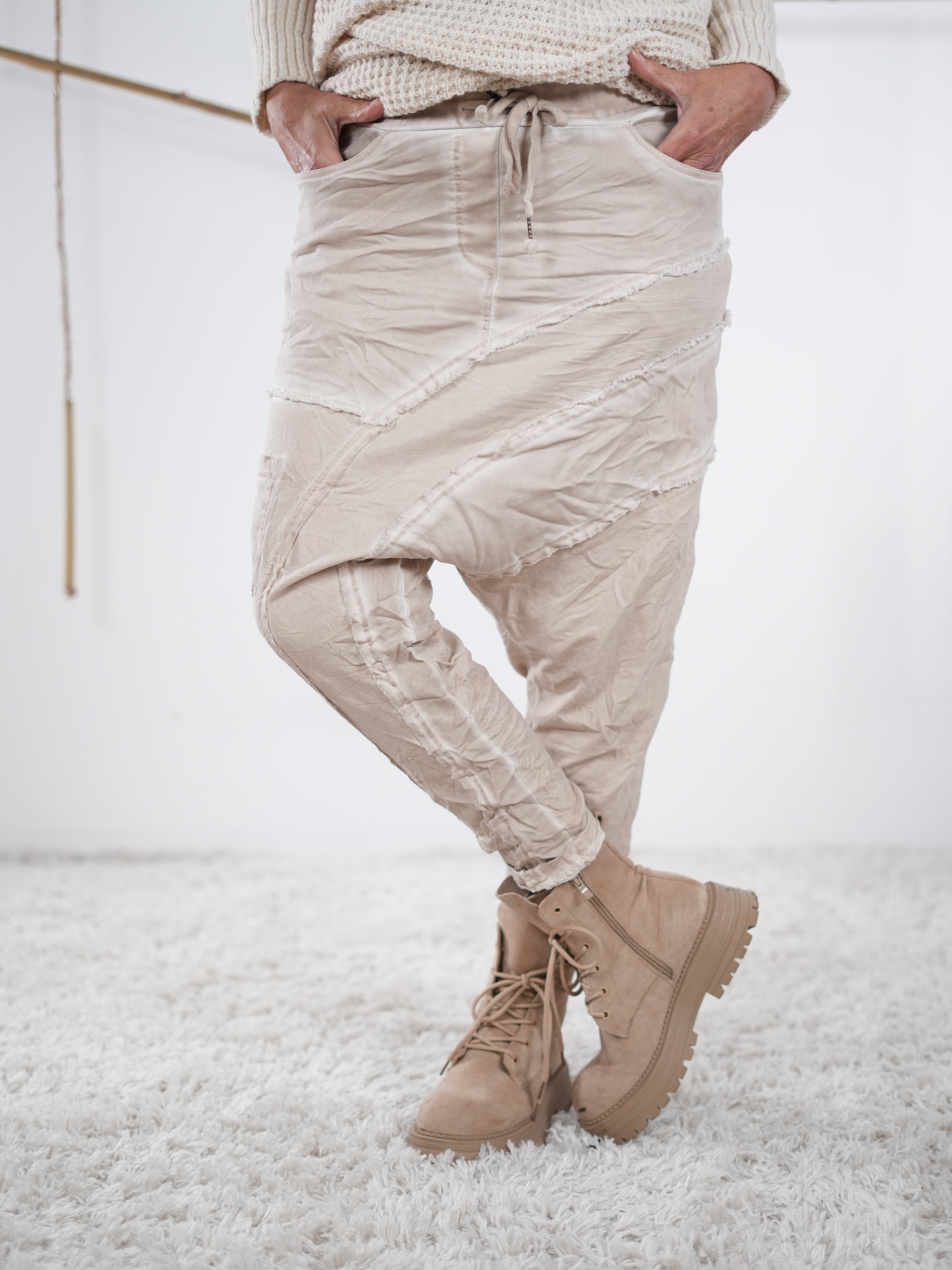 Beigefarbene Baggyhose mit leicht verwaschener Optik und diagonalen Außennaht-Details.