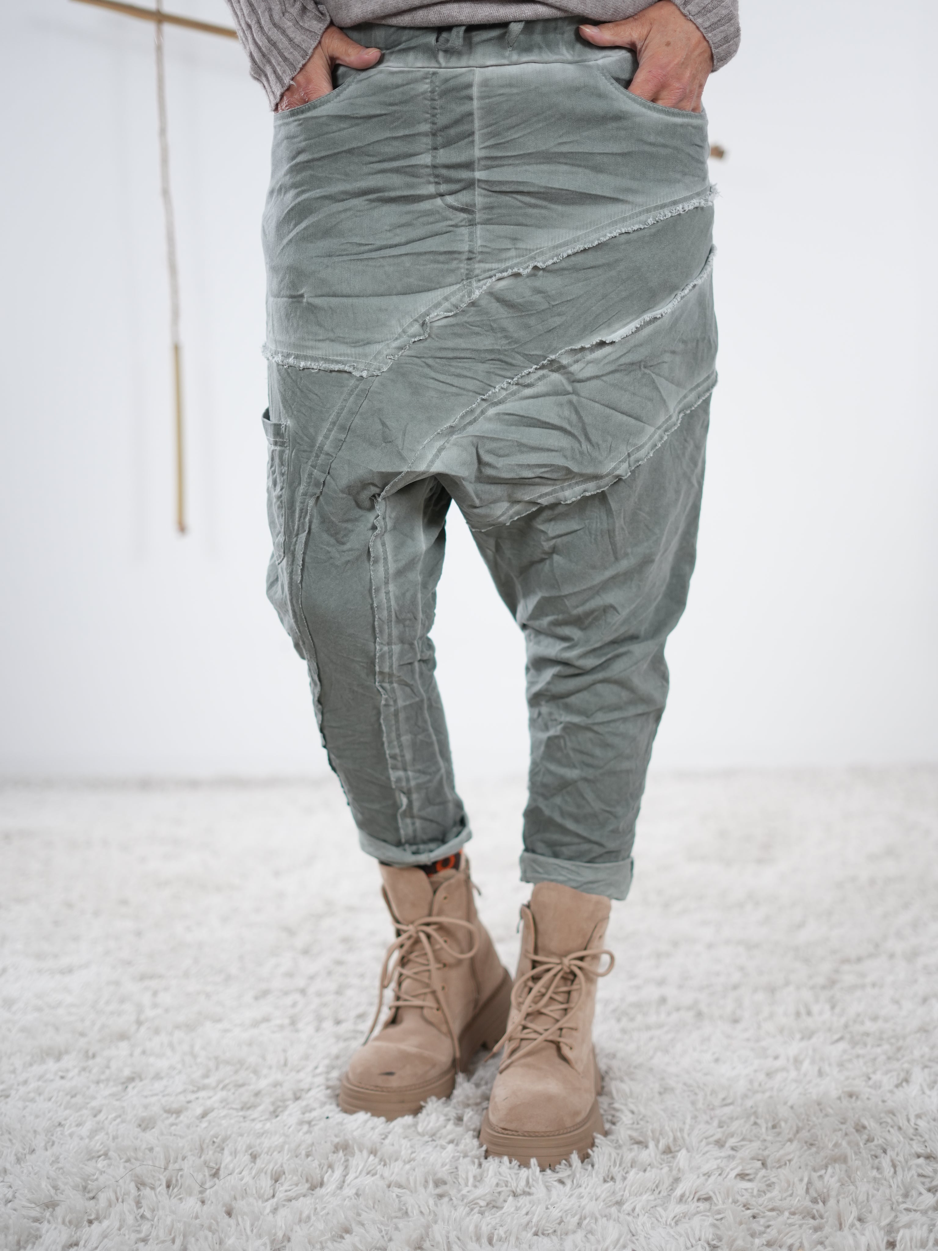 Olivefarbene Baggyhose mit asymmetrischen Außennaht-Details und verwaschener Optik
