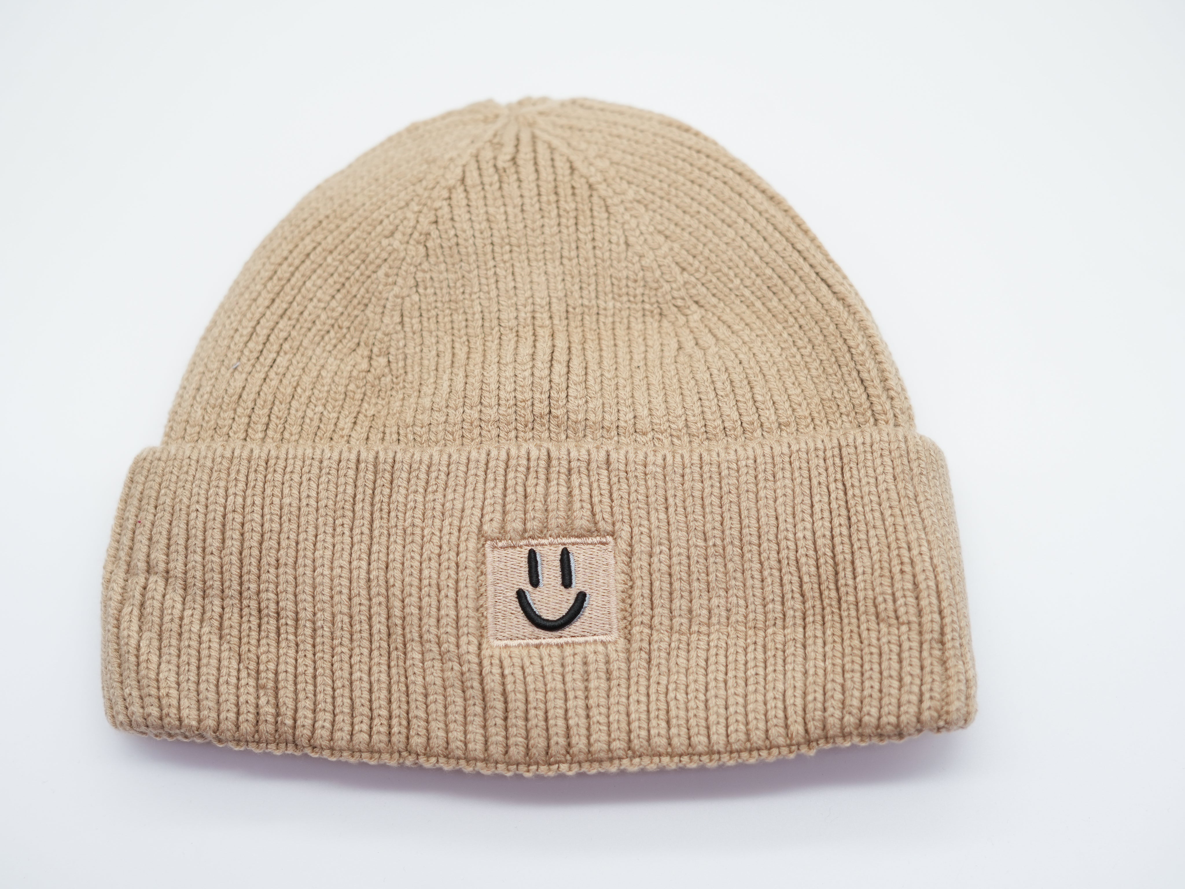 Beige Damen Beanie Mütze aus geripptem Strick mit aufgenähtem Smiley-Patch, warme Wintermütze.