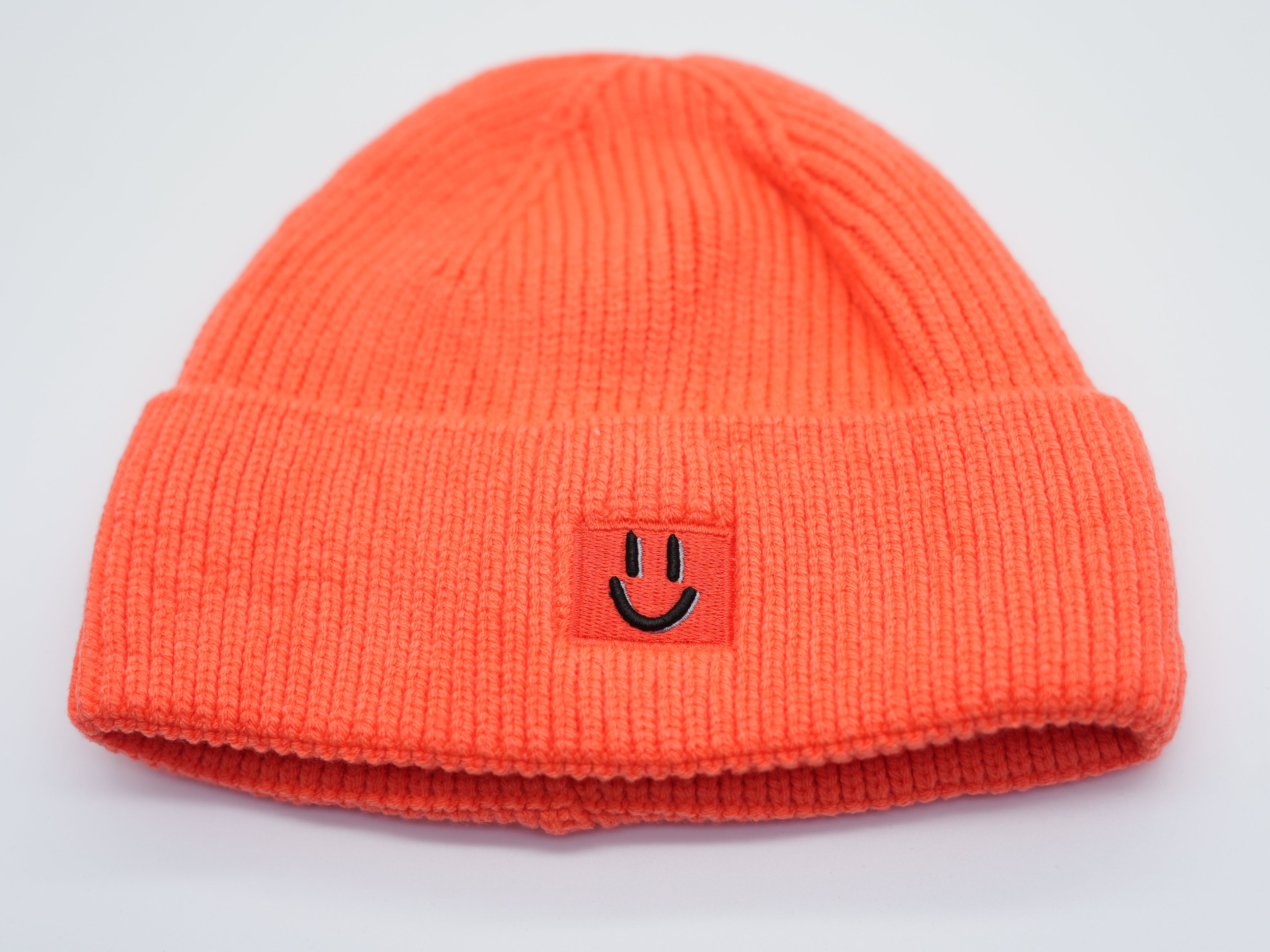 Leuchtend orange Damen Strickmütze mit Smiley-Patch, warme Beanie mit umgeschlagenem Bündchen.