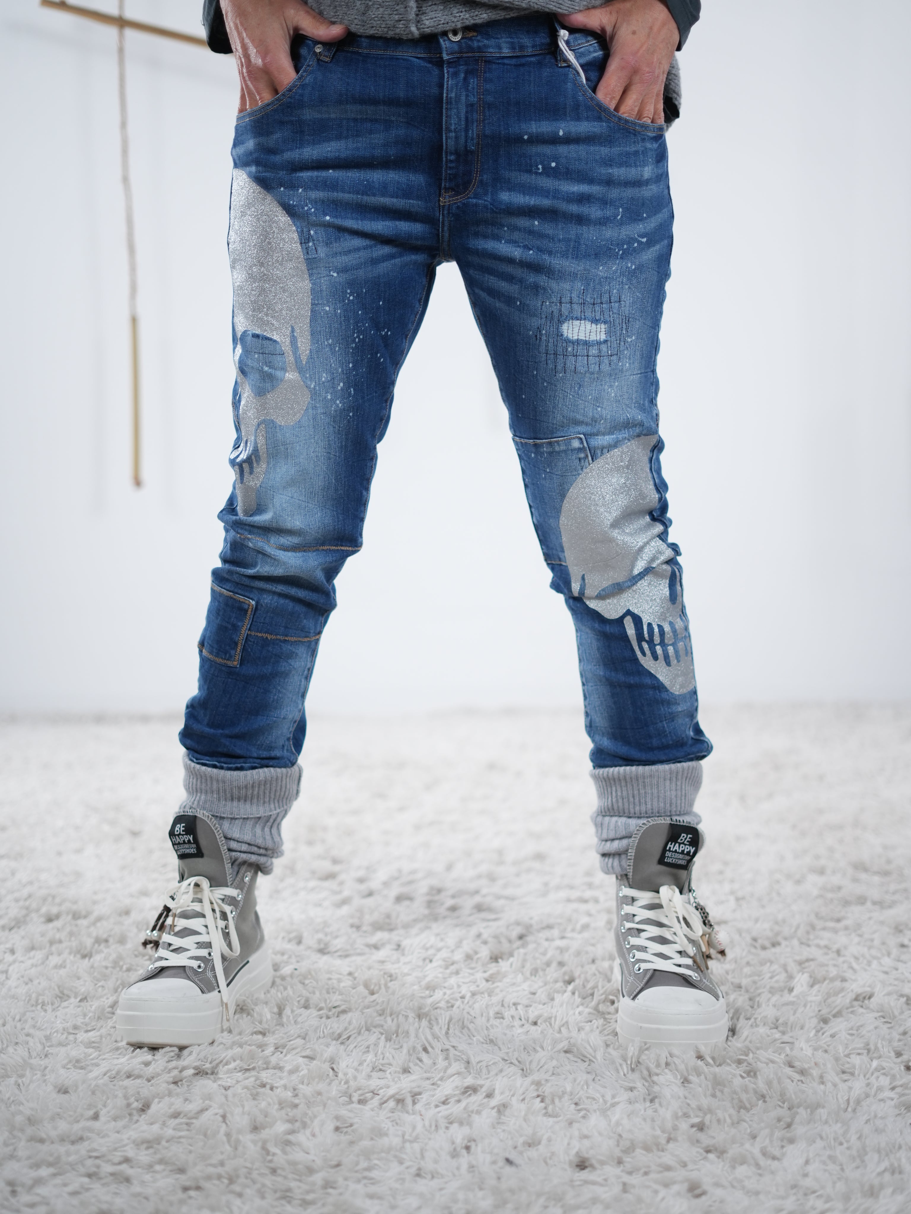 Frontansicht der Blue Jeans. Lässige Passform mit silbernen Skulls verziert.