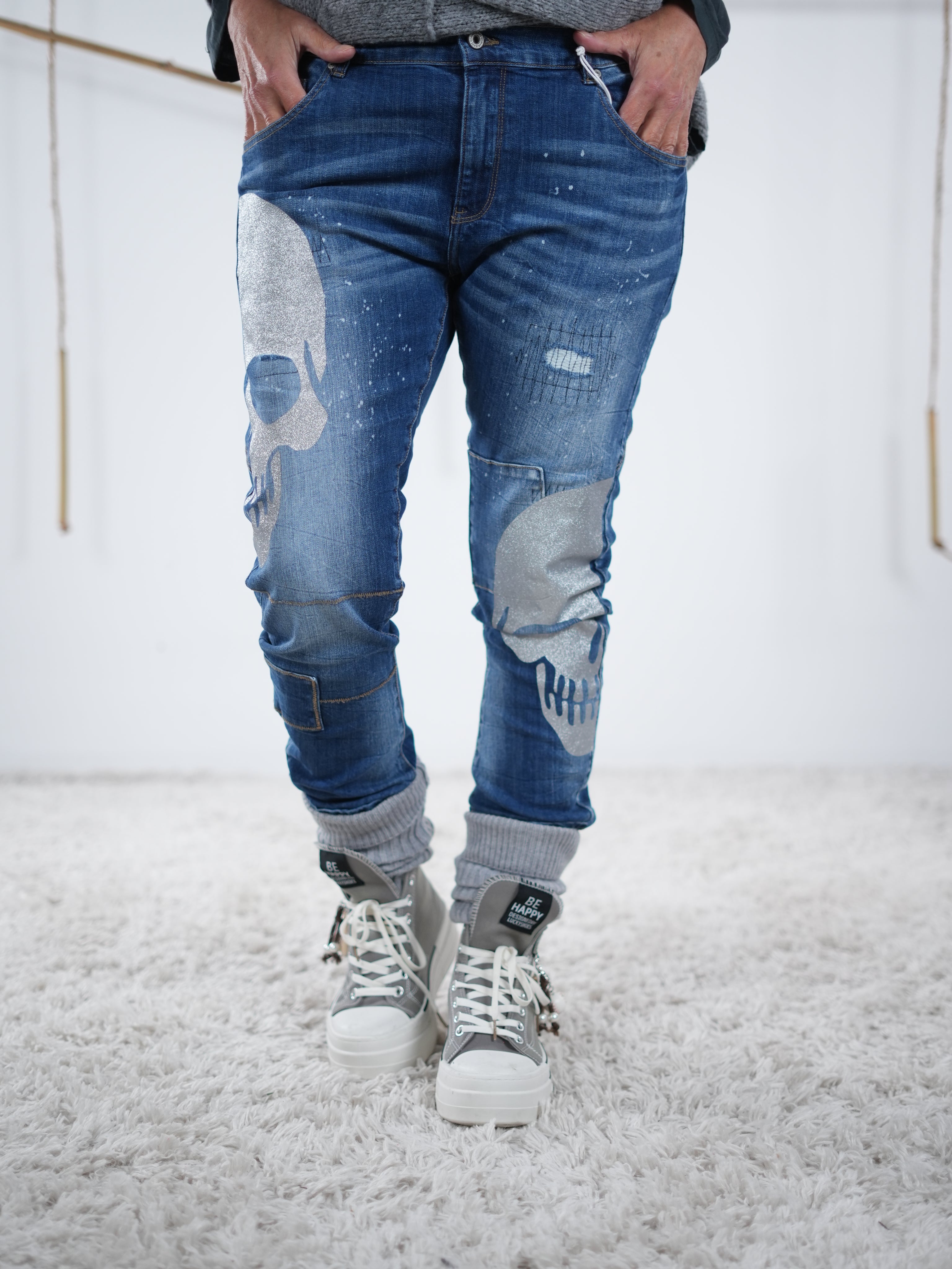 Die Blue Jeans mit silbernen Skulls wird in lässiger Position präsentiert
