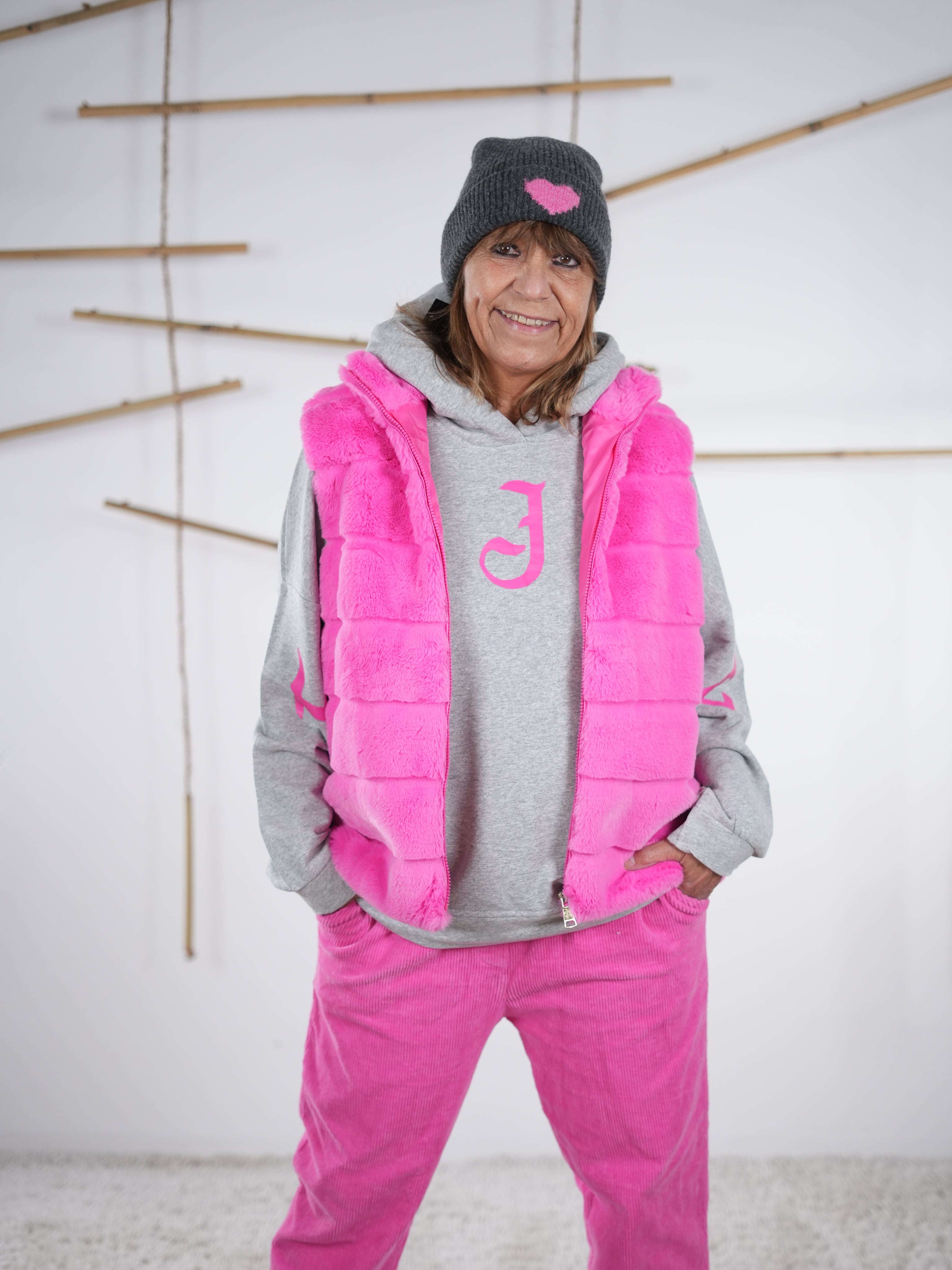 Flauschige, gerade geschnittene Weste in knalliger pinken Farbe, Frontansicht mit Reißverschluss und seitlichen Eingriffstaschen