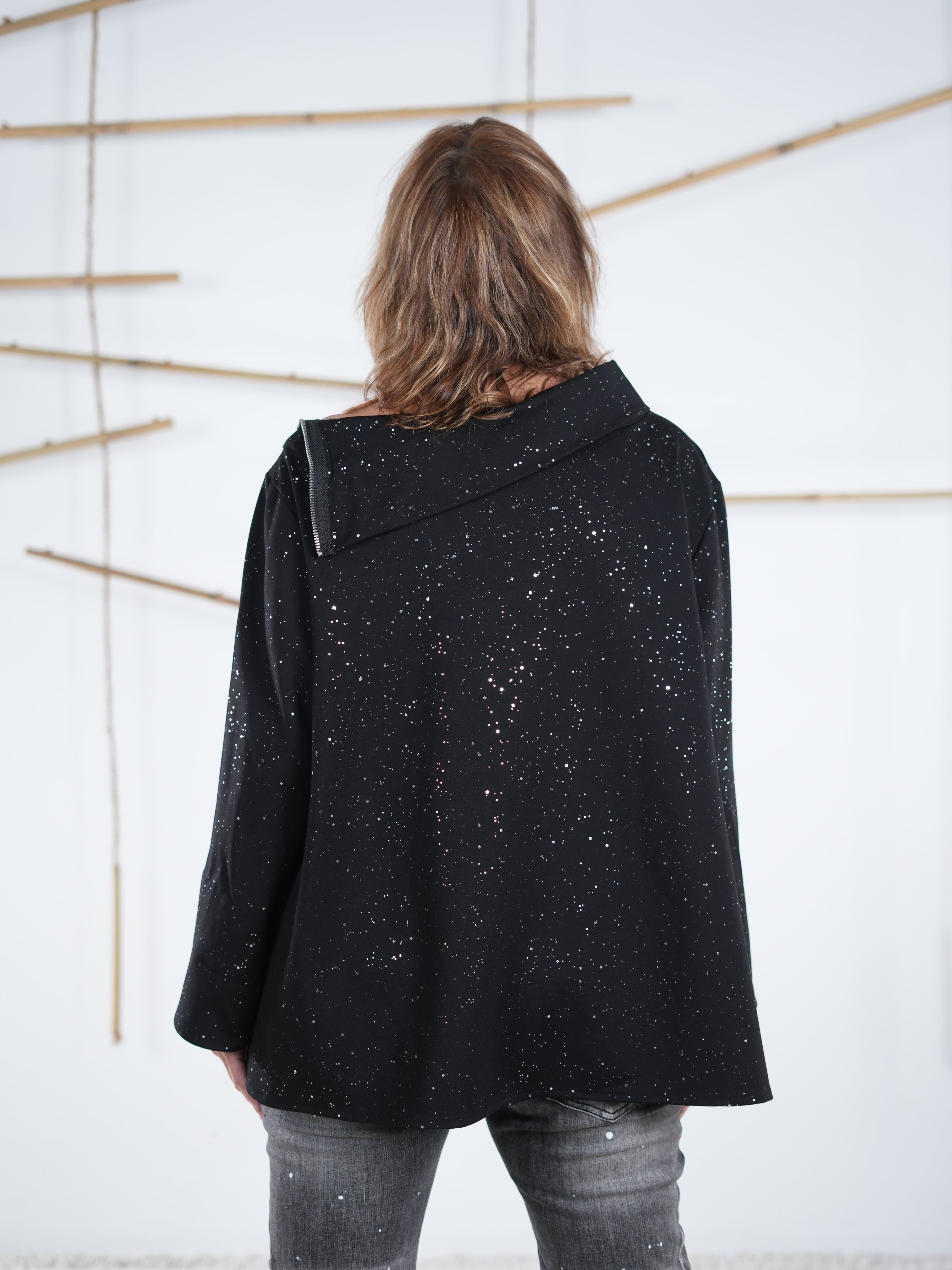 Rückansicht eines schwarzen Pullis mit Glitzer-Effekt und locker fallendem Schnitt