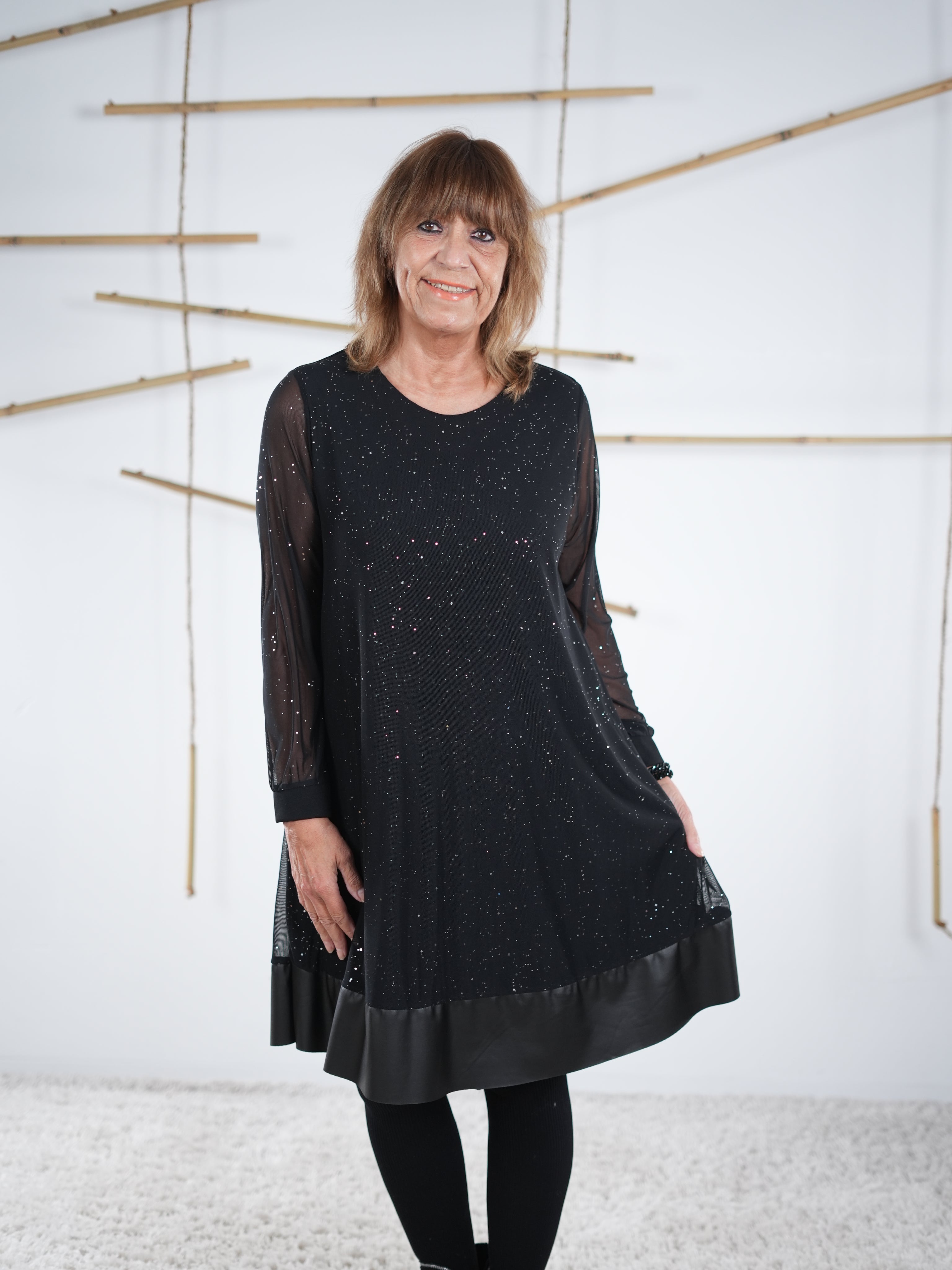 Locker fallendes schwarzes Glitzerkleid mit Mesh-Ärmeln und Kunstleder-Abschluss, frontale Ansicht