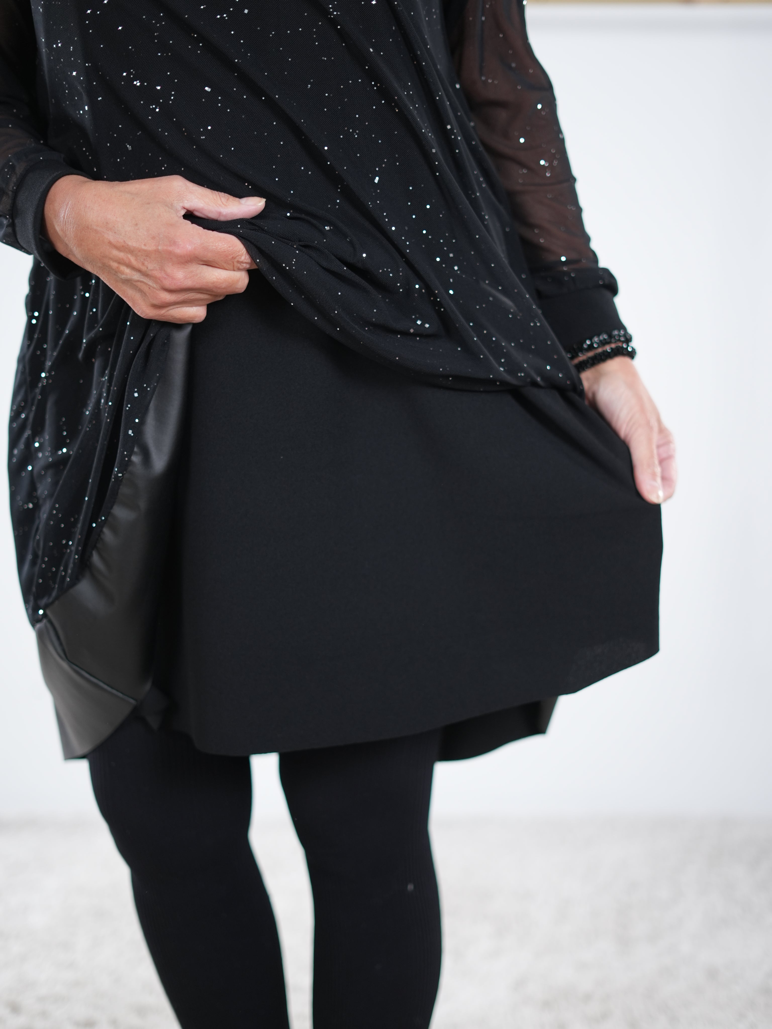 Detailaufnahme des Innenfutters eines schwarzen Glitzerkleids mit mehrlagigem Stoff