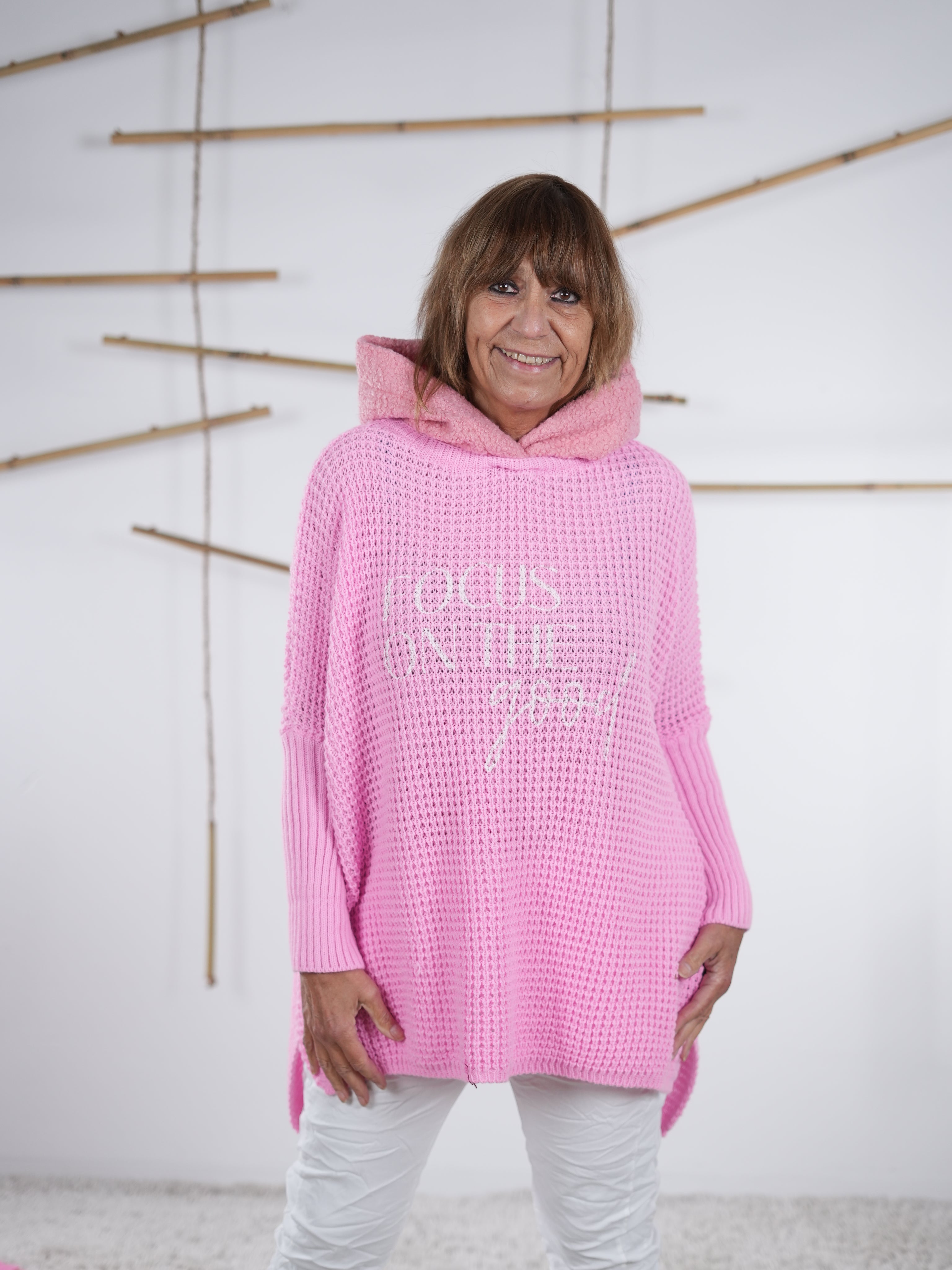 Rosafarbener Grobstrickpulli mit Kapuze, überschnittenen Ärmeln und lässigem Fit.