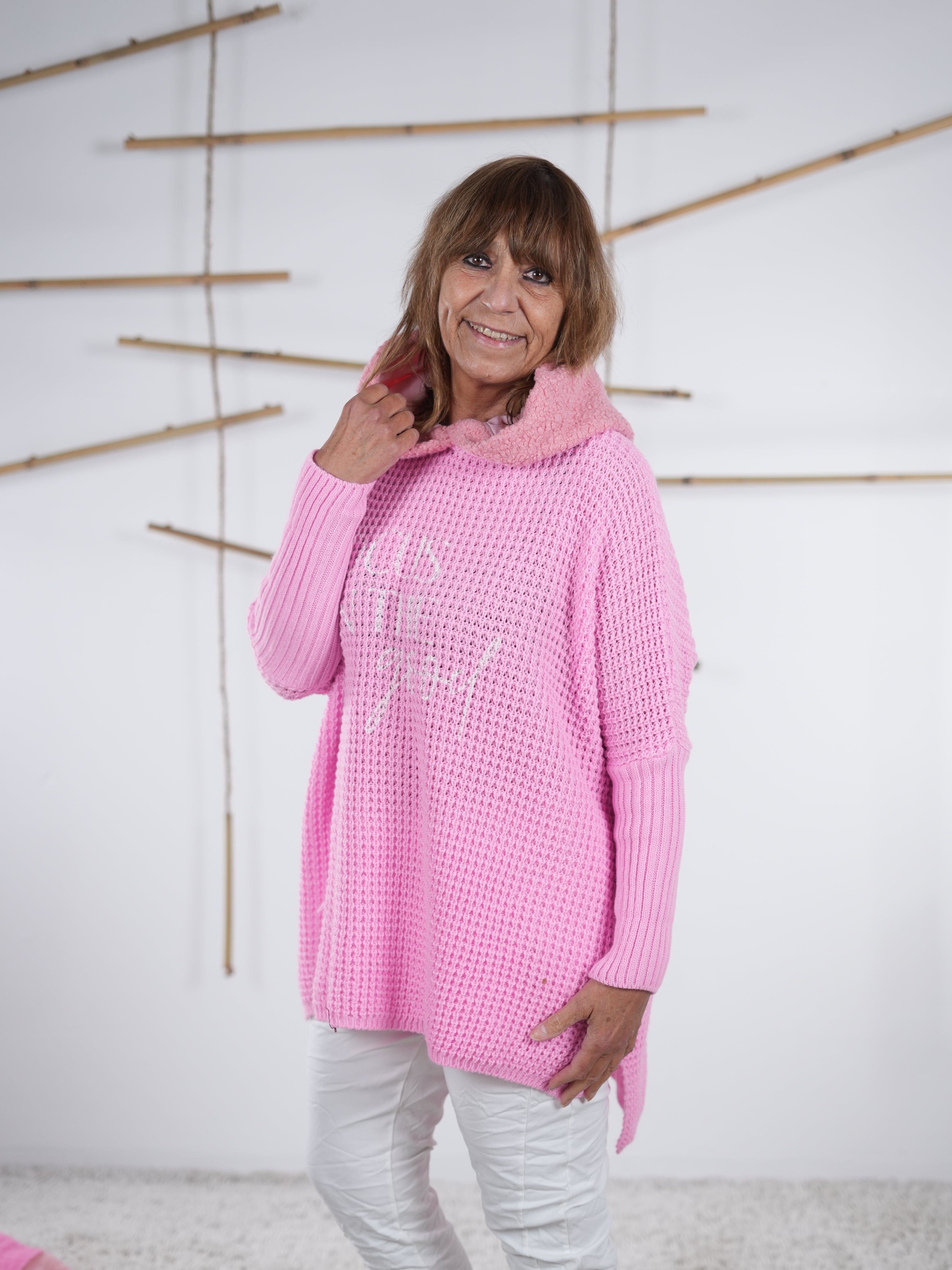 Rosafarbener Grobstrickpulli mit längerem Rückenteil und grober Strickoptik