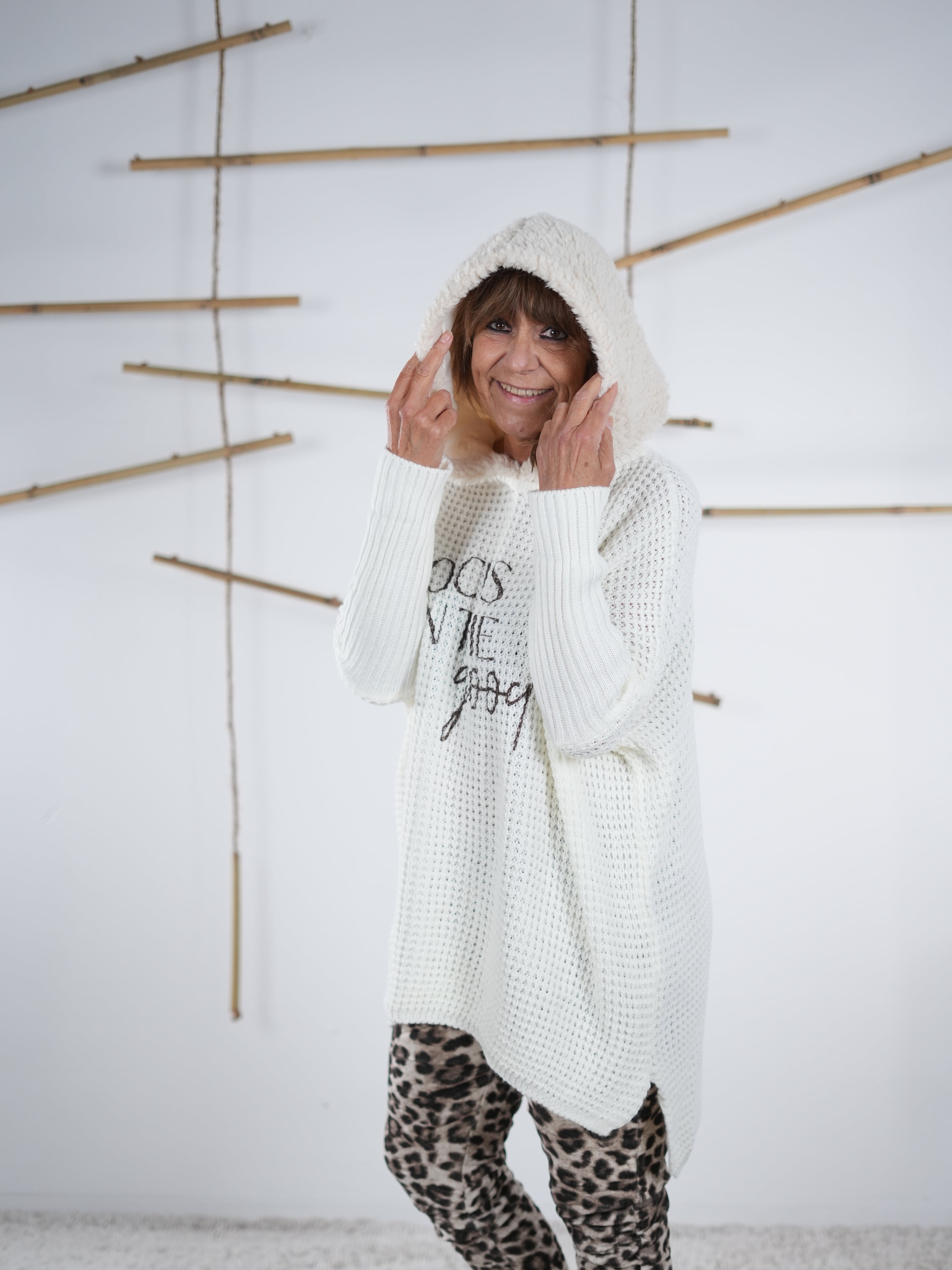 flauschiger Grobstrickpulli mit schwarzem Schriftzug in wollweiß. Detailaufnahme der flauschigen Kapuze.