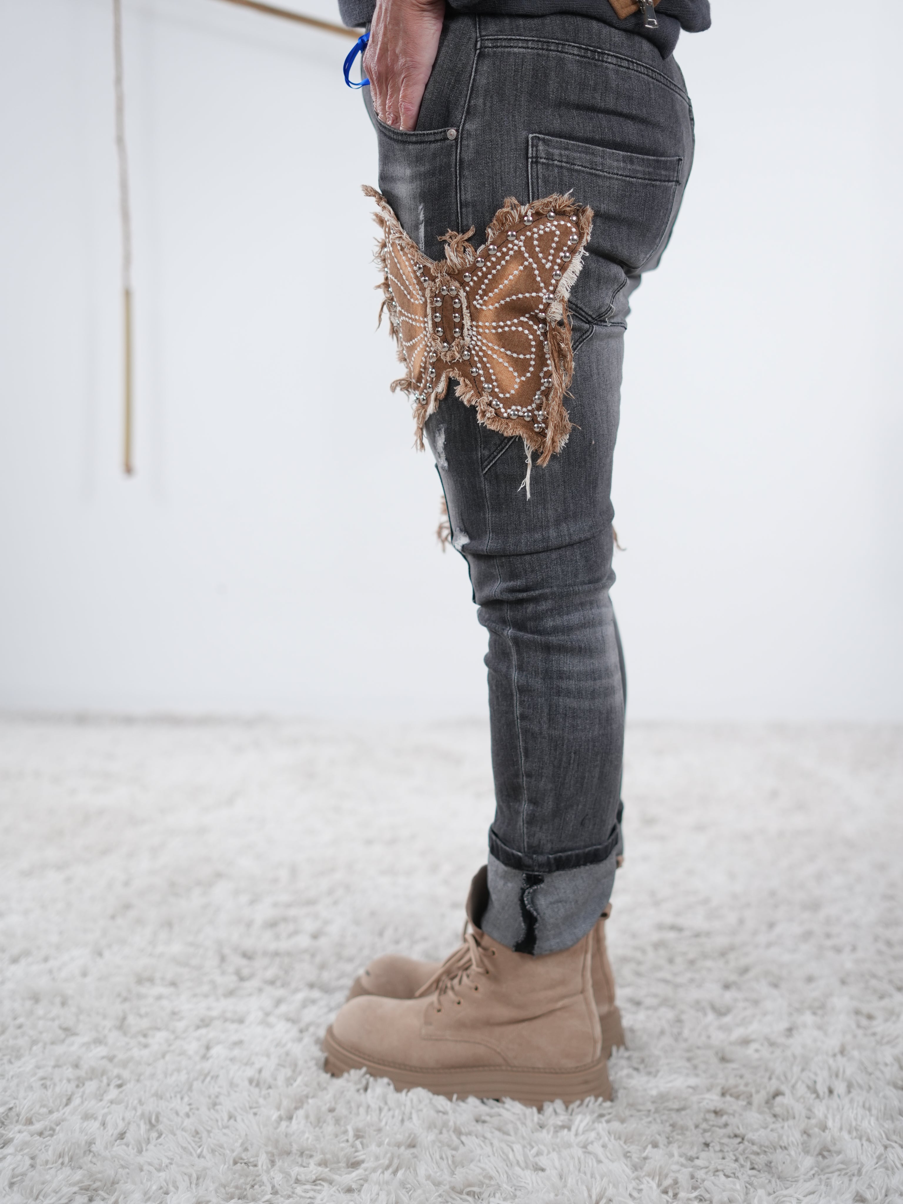 damen jeans in anthrazit mit präsentem schmetterlingspatch. Seitliche eingriffstaschen im fokus