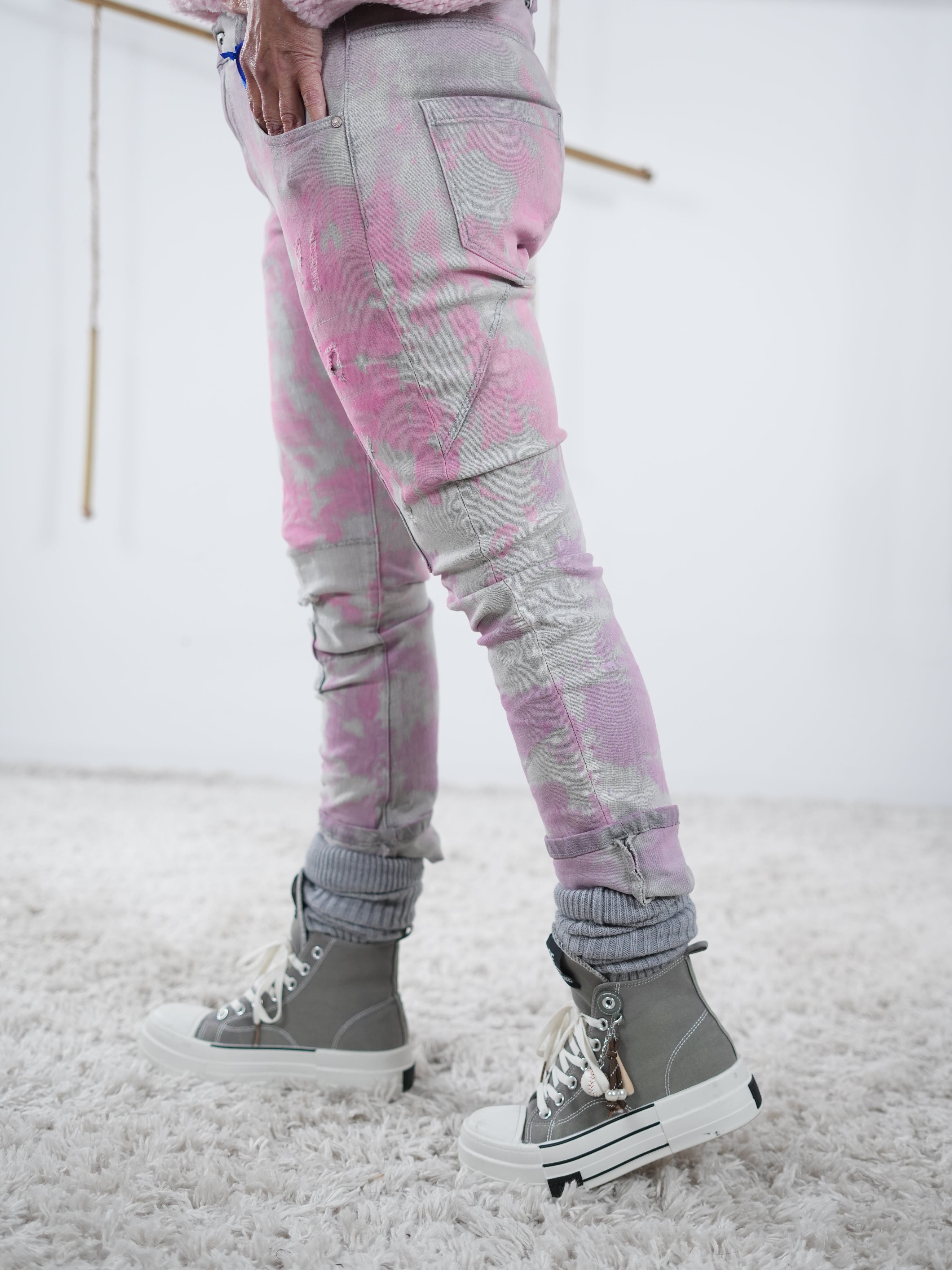 Graue Jeans mit pinken Details in der seitlichen Ansicht.