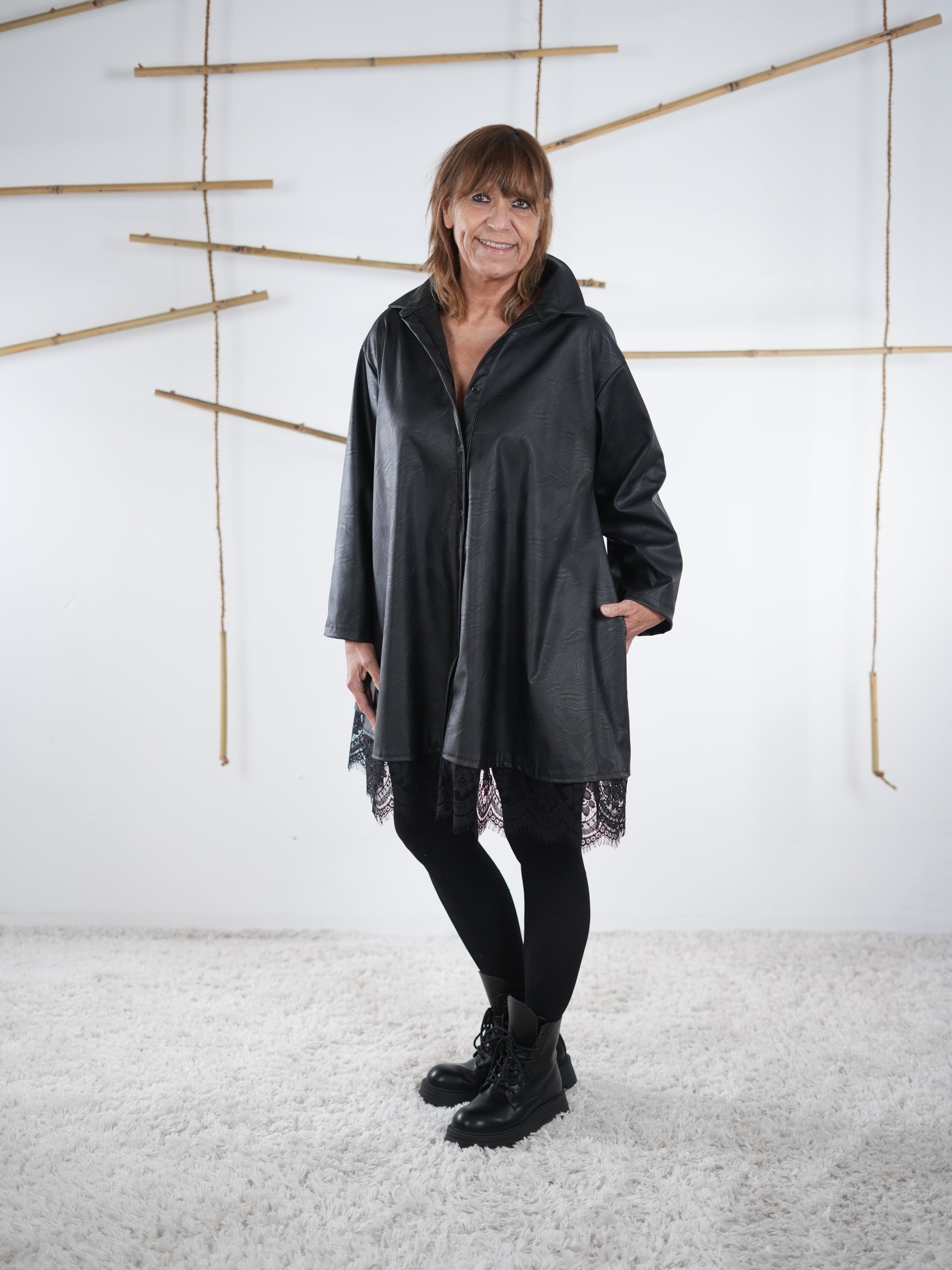 Schwarze Kunstleder-Tunika mit Spitzensaum, frontal getragen von Marion.
