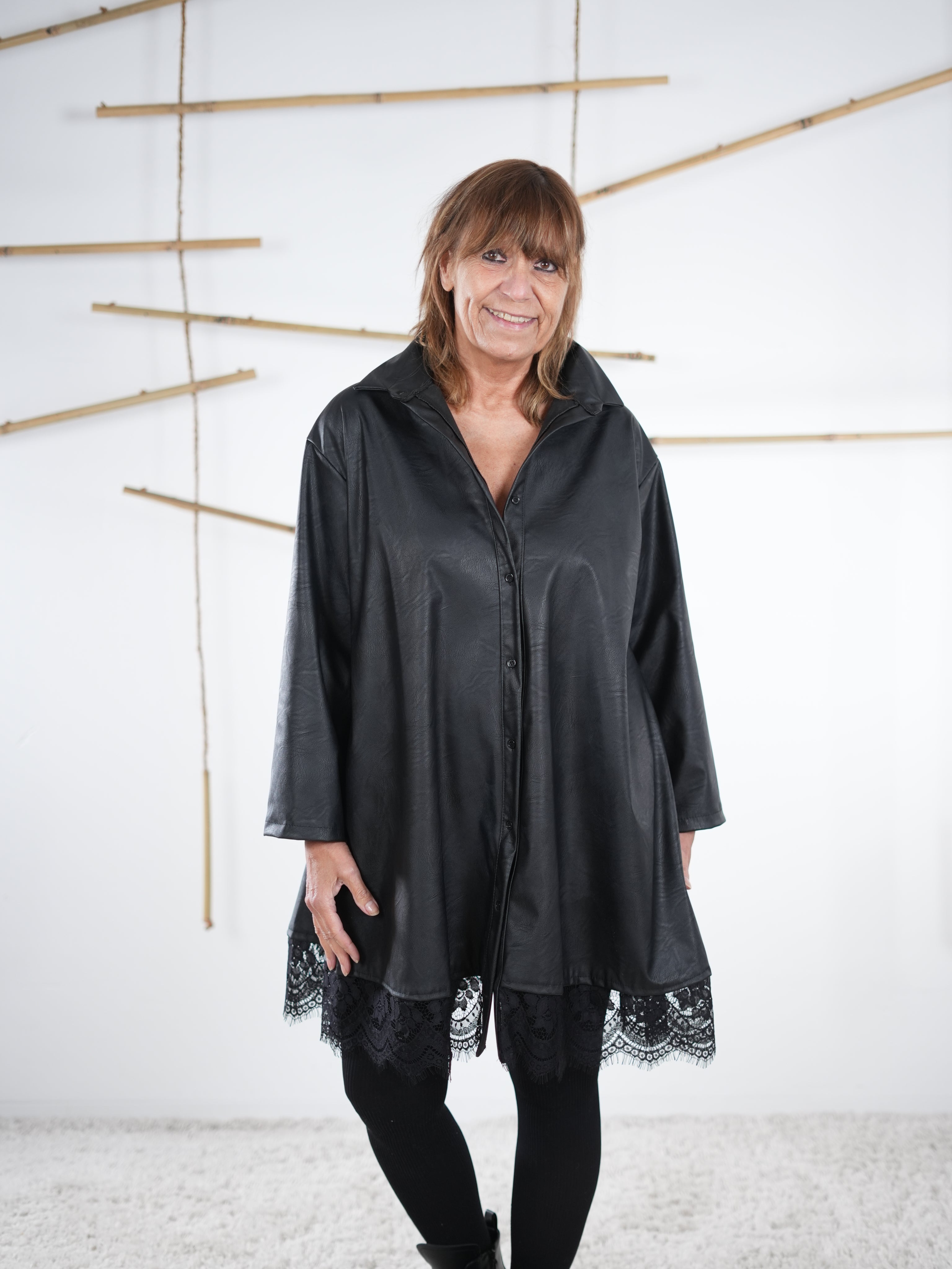 Schwarze Kunstleder-Tunika mit Spitze, Vorderansicht mit Kragen und Knopfleiste.