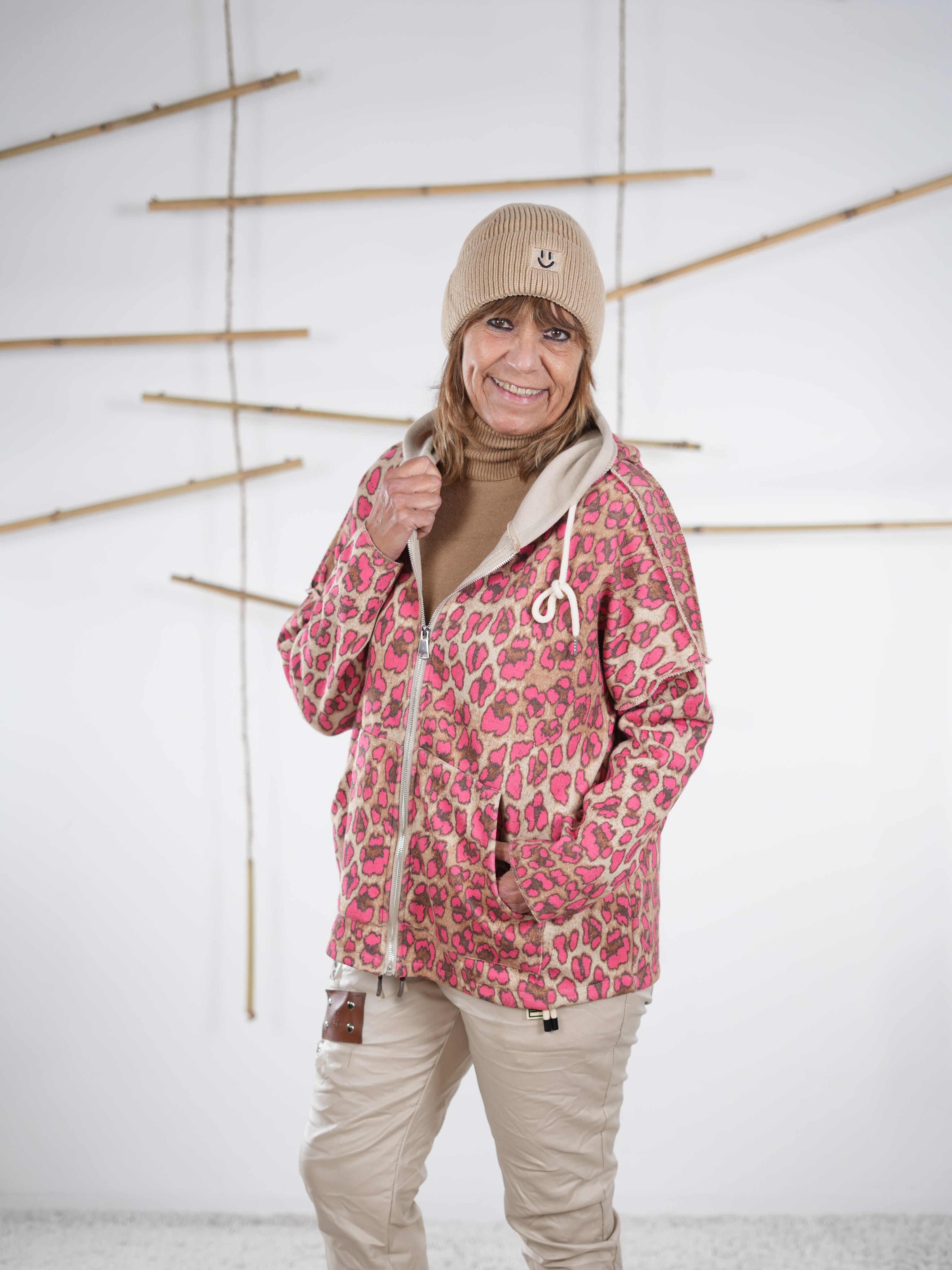 Pinkfarbene Leo-Sweatjacke mit Kapuze in halbseitiger Frontansicht.