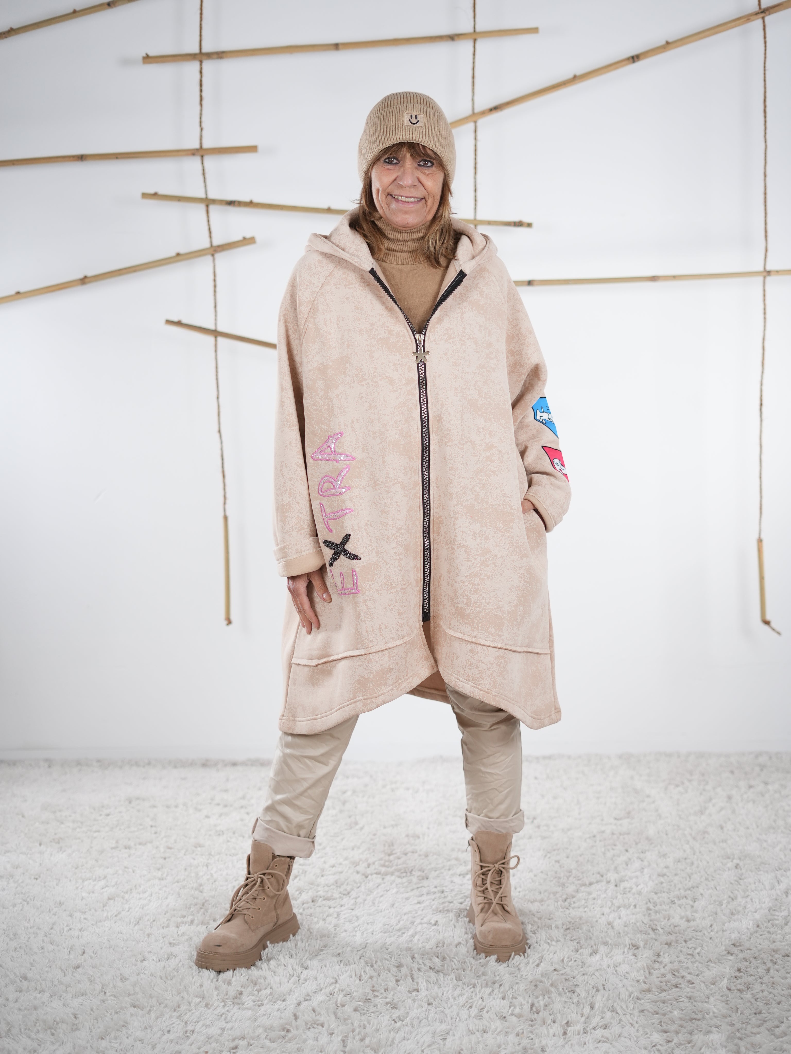 Beiger Mantel mit Kapuze und Comic-Details, Frontansicht