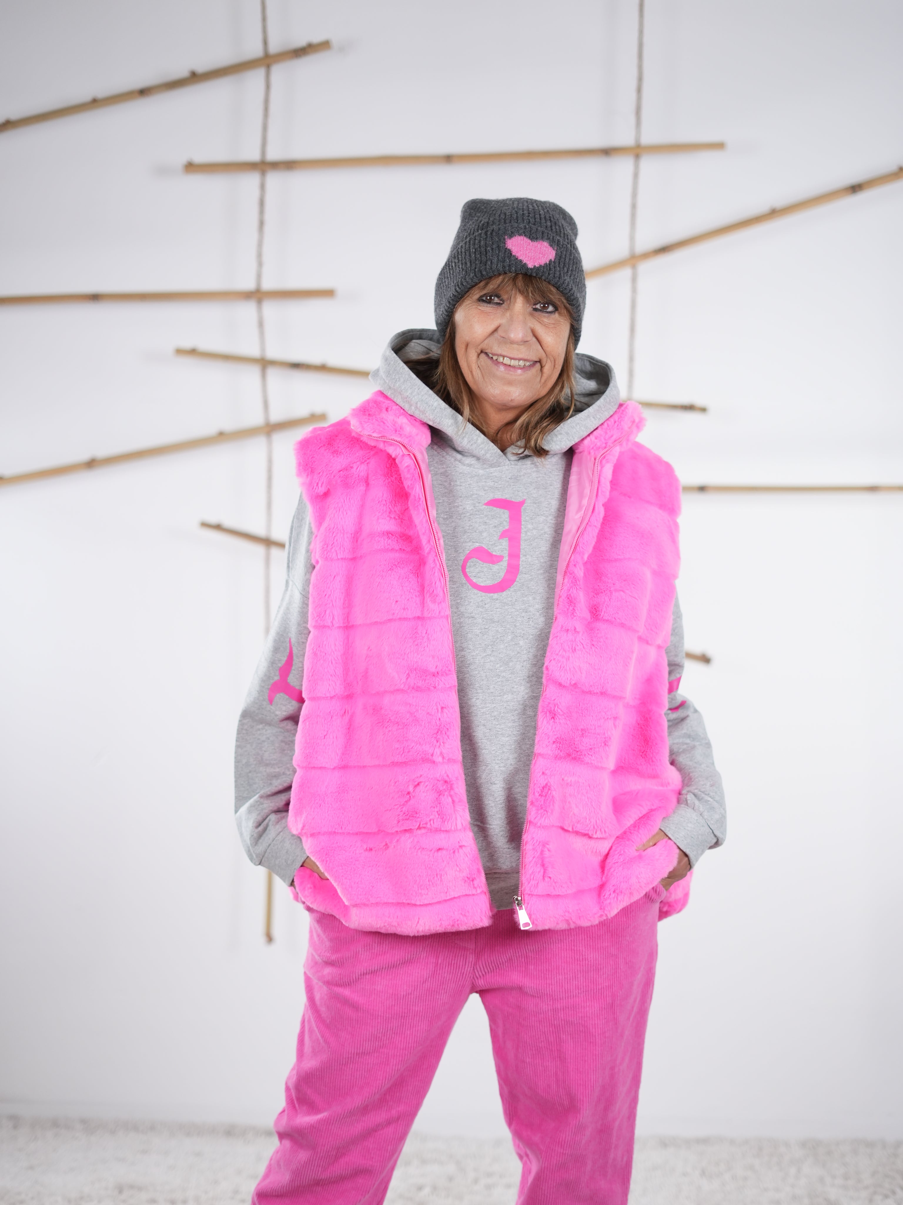 Pinke Flausch-Weste offen getragen, locker fallend und kuschelig strukturiert.