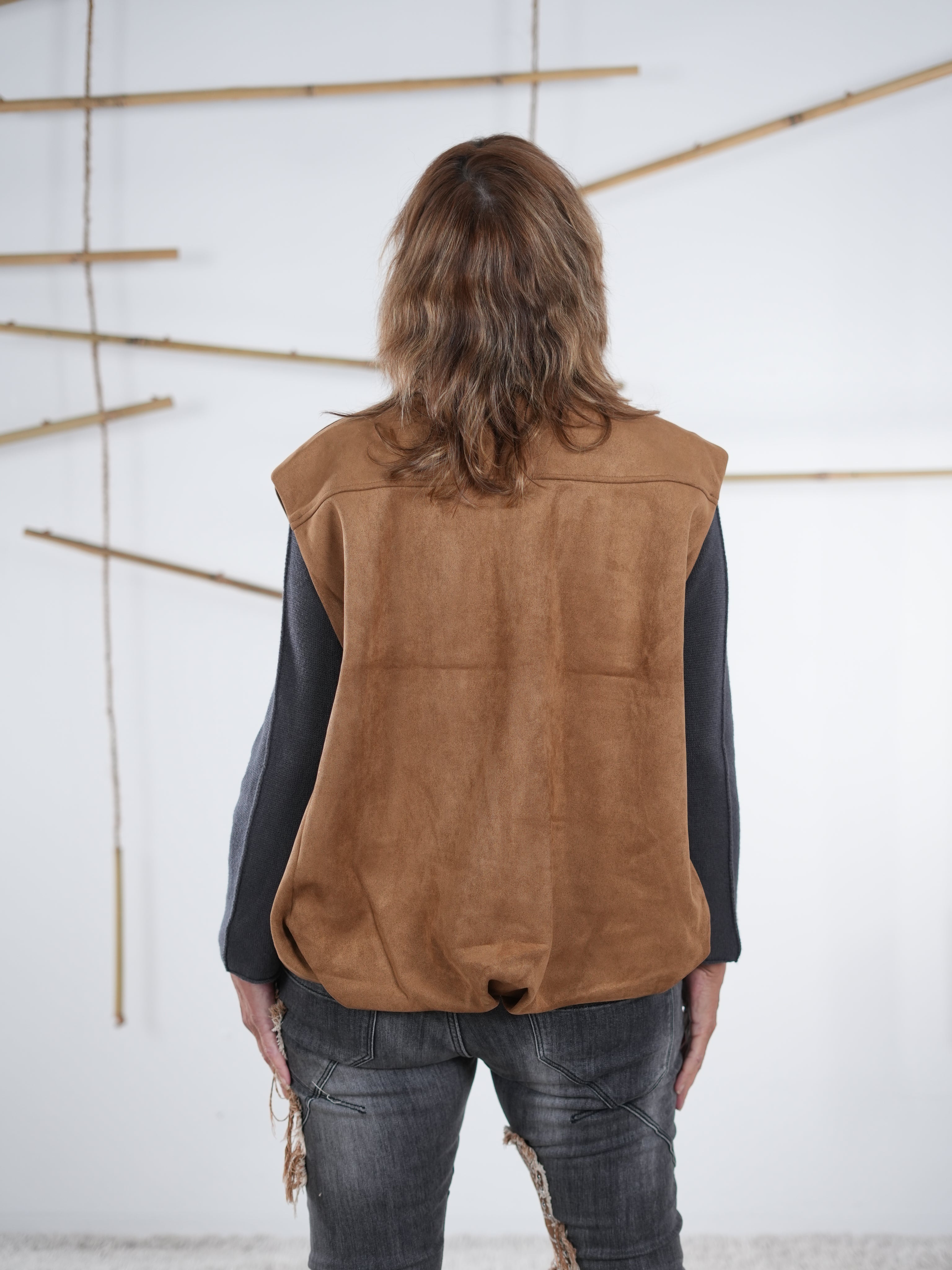 Rückansicht der camelfarbenen Velours-Weste in Lederoptik mit elastischem Abschluss.