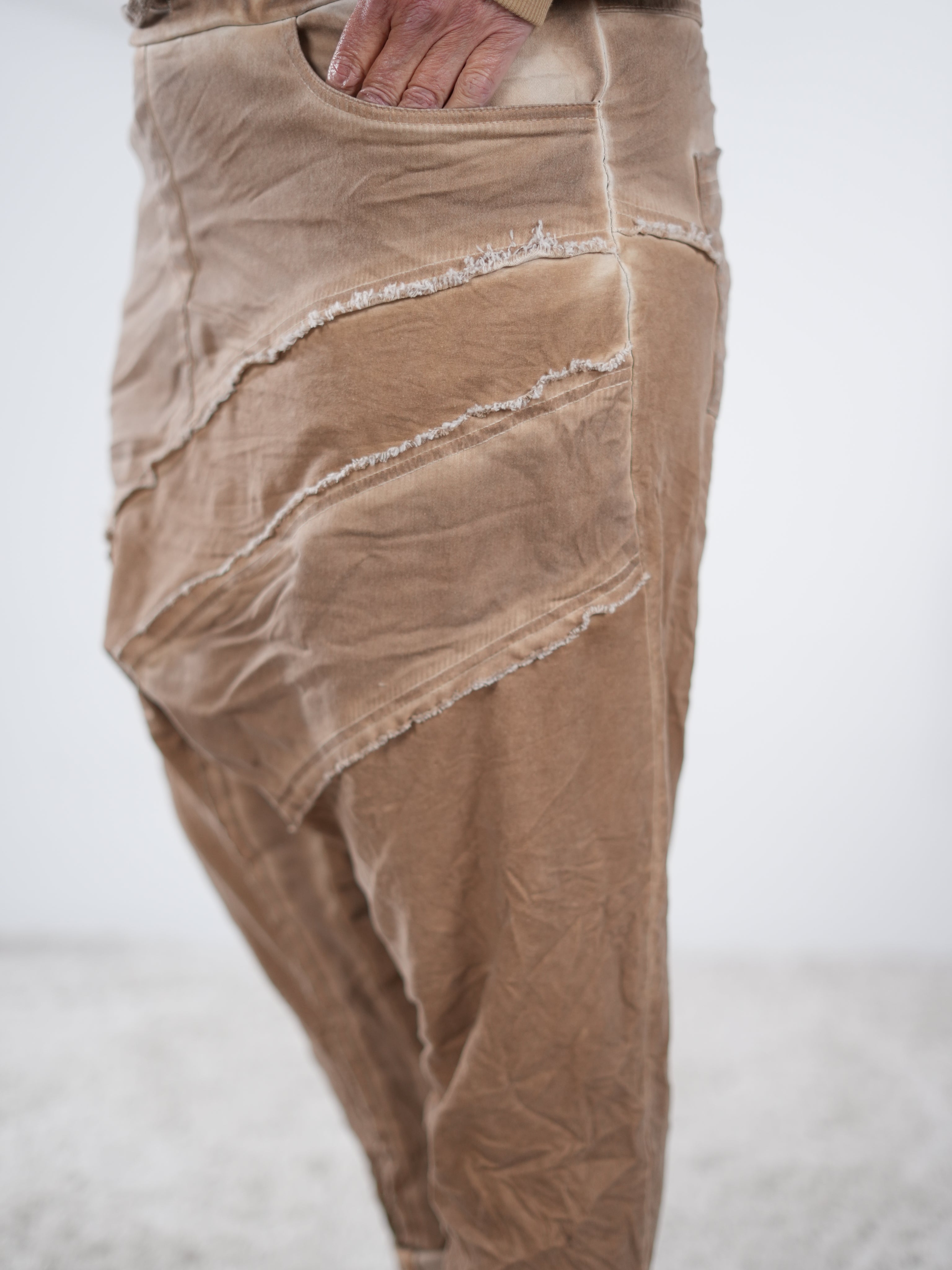 Detailaufnahme der camelfarbenen Baggyhose mit ausgefransten Außennaht-Elementen