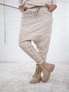 Beigefarbene Baggyhose mit leicht verwaschener Optik und diagonalen Außennaht-Details.