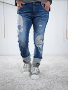 Die Blue Jeans mit silbernen Skulls wird in lässiger Position präsentiert 