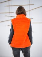 Marion präsentiert das Rückenteil der flauschigen Weste in orange.