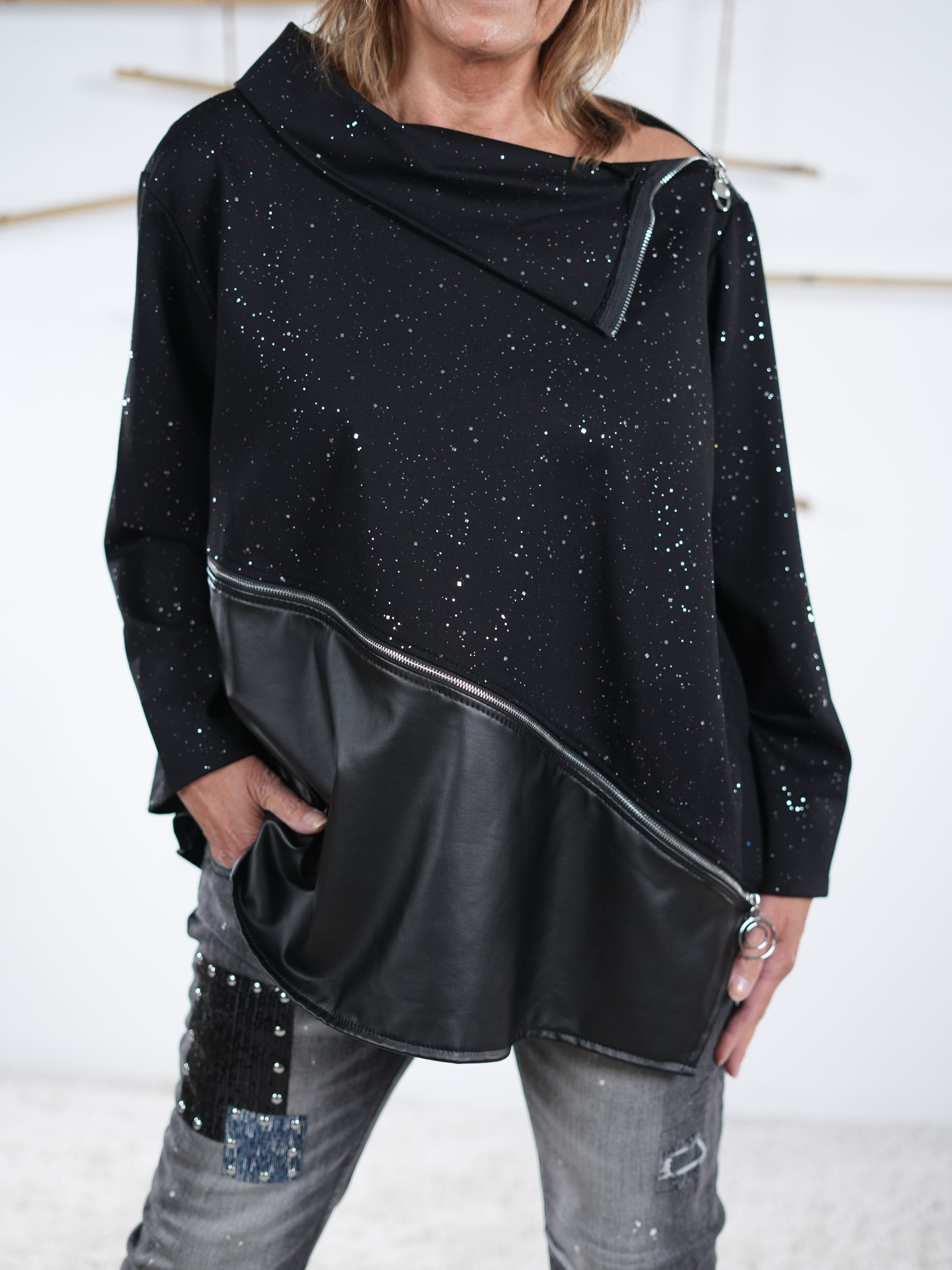 Glitzernder schwarzer Pullover mit schrägem Kunstleder-Einsatz und dekorativem Reißverschluss, Frontdetail