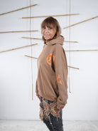 Damen-Hoodie in camel mit großem orangefarbenem Letter-Print vorne, seitliche Ansicht