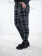 Seitliche Ansicht auf die karierte Jogpant. Das karierte Muster ist in schwarz weiß gehalten.