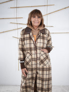 Frau trägt karierten Fleece-Mantel mit braunen Strickbündchen, Nahaufnahme der Vorderseite