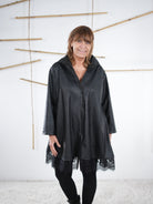 Schwarze Kunstleder-Tunika mit Spitze, Vorderansicht mit Kragen und Knopfleiste.