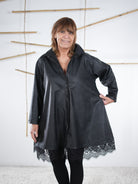 Weit geschnittene Kunstleder-Tunika mit Spitze am Saum, leicht ausgestellt.