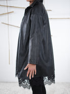 Seitenansicht der Kunstleder-Tunika mit betontem Saum aus Spitze.