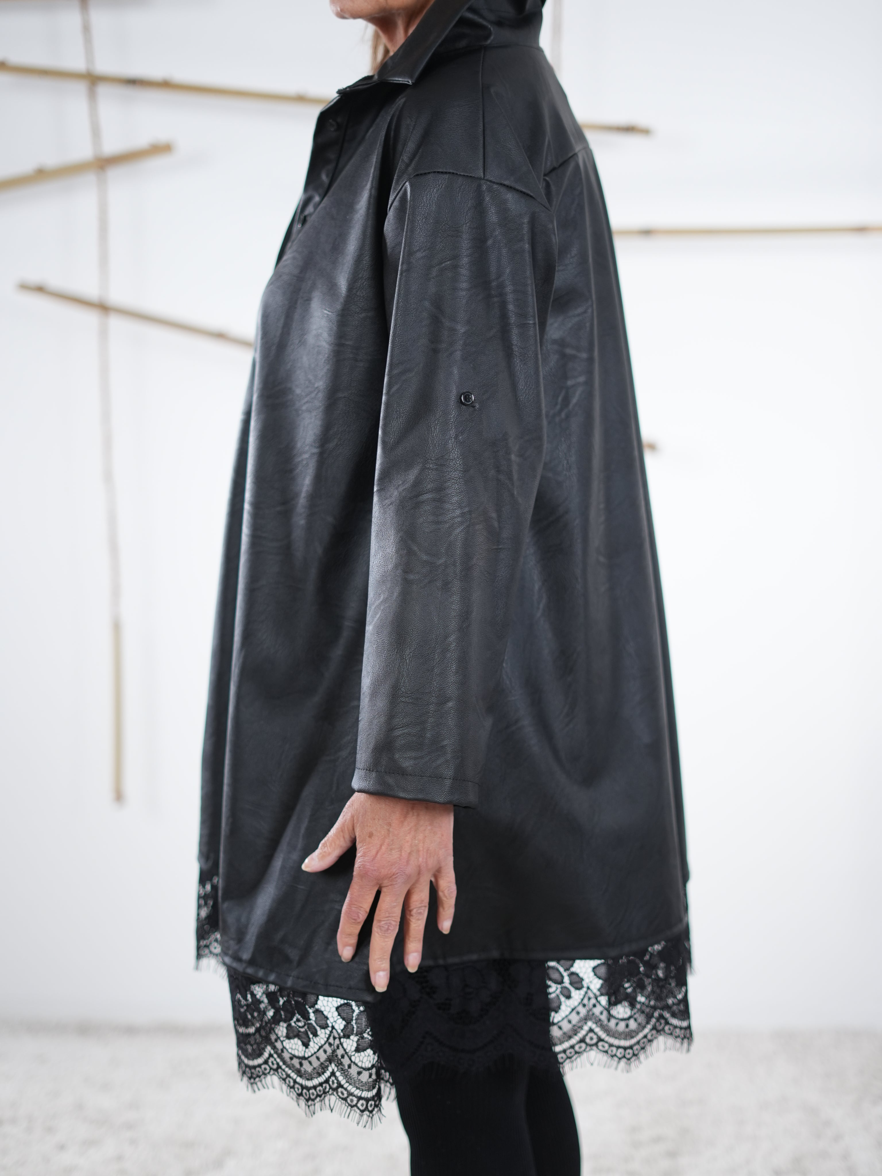 Seitenansicht der Kunstleder-Tunika mit betontem Saum aus Spitze.