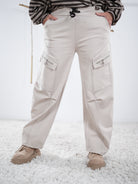 Beige Cargo-Wide-Leg-Hose mit auffälligen Nähten und seitlichen Zipper-Taschen, vorne getragen
