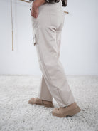 Beige Wide-Leg-Hose mit dekorativen Nähten und Zipper-Details, leicht seitliche Ansicht