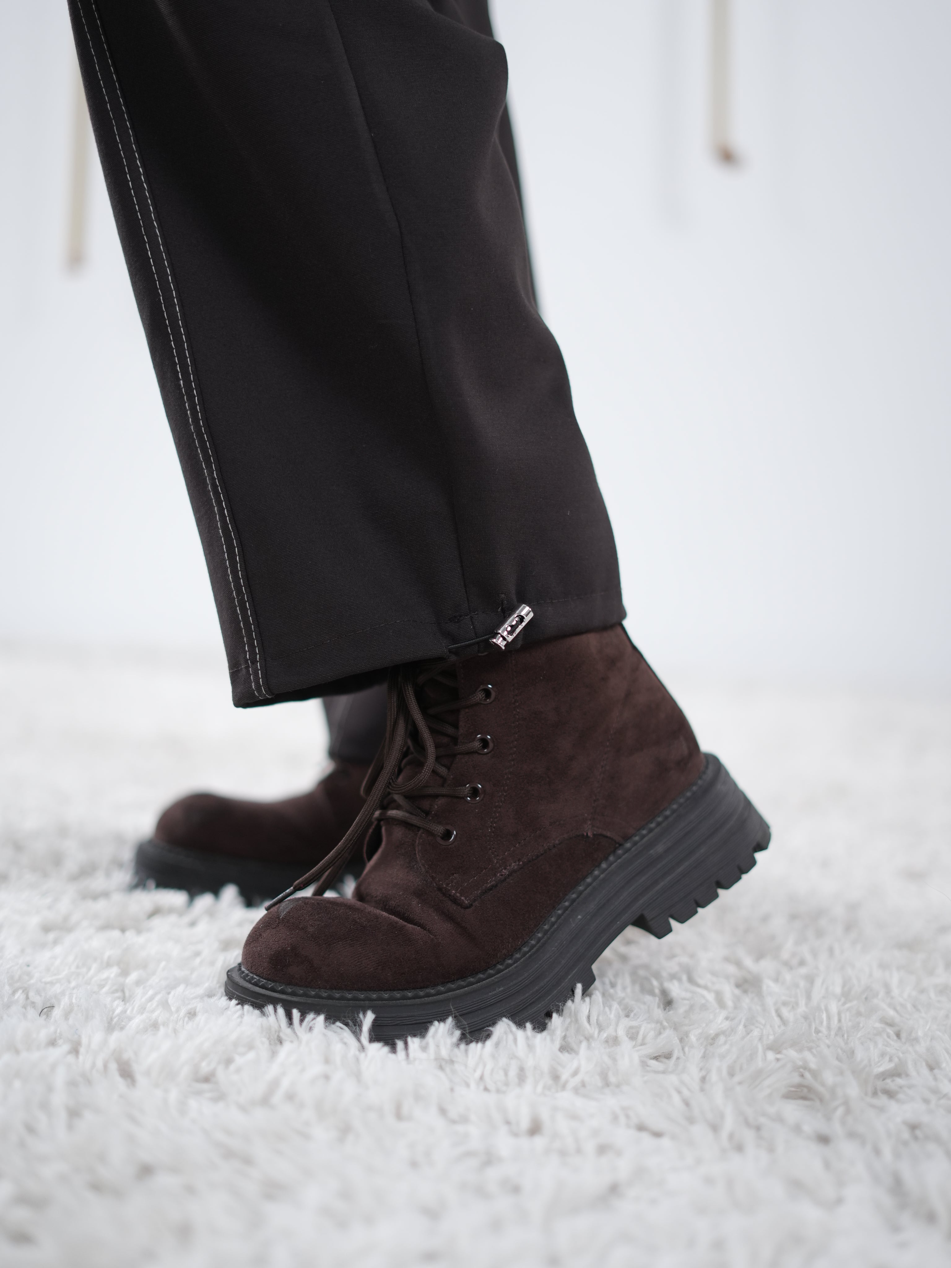 Nahaufnahme des Beinabschlusses einer schokobraunen Wide-Leg-Hose mit kleinem seitlichen Gummibund