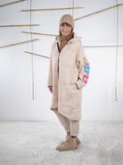 Beiger Oversize-Mantel mit Comic-Motiven, vorne geschlossen