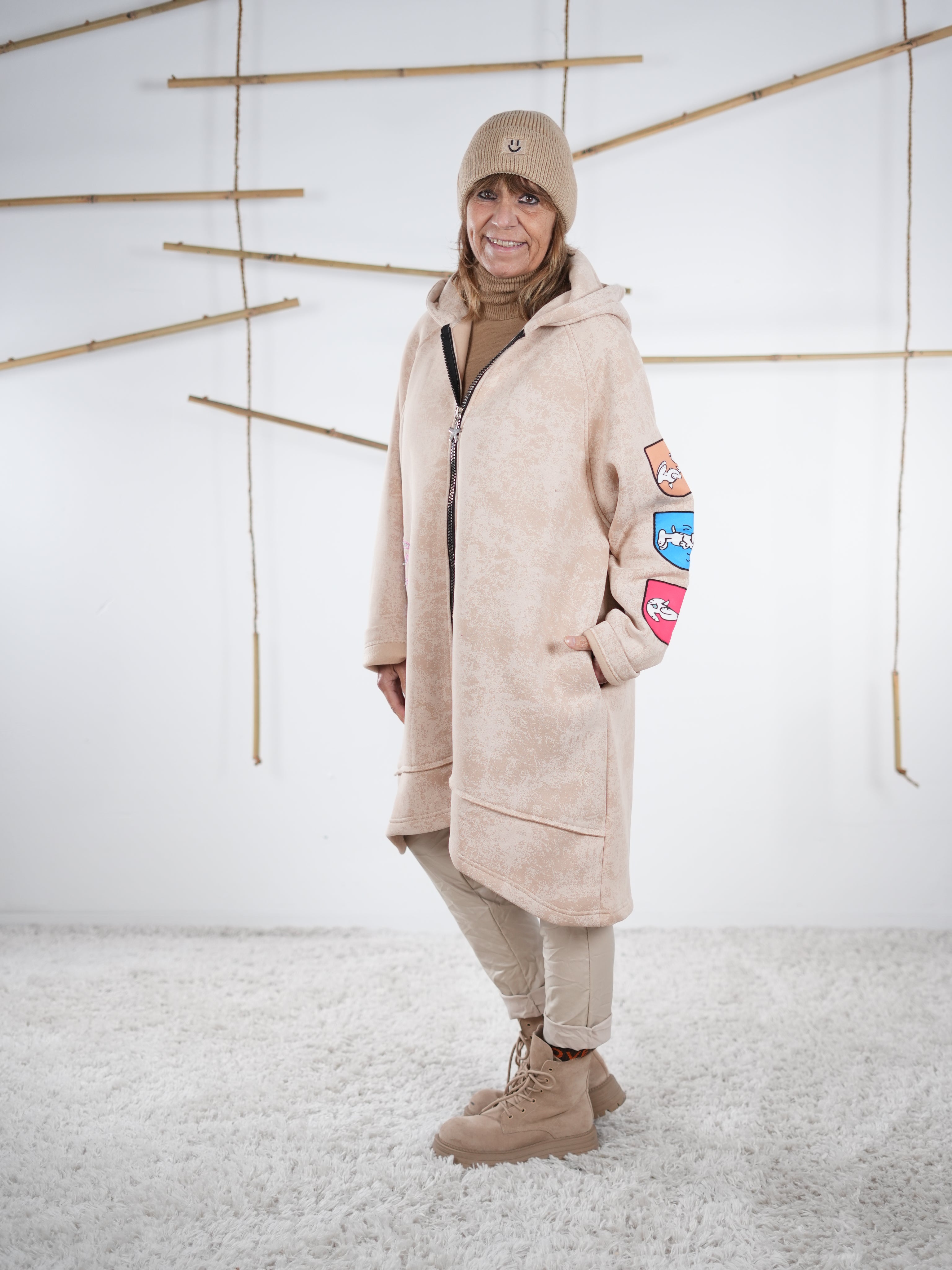 Beiger Oversize-Mantel mit Comic-Motiven, vorne geschlossen