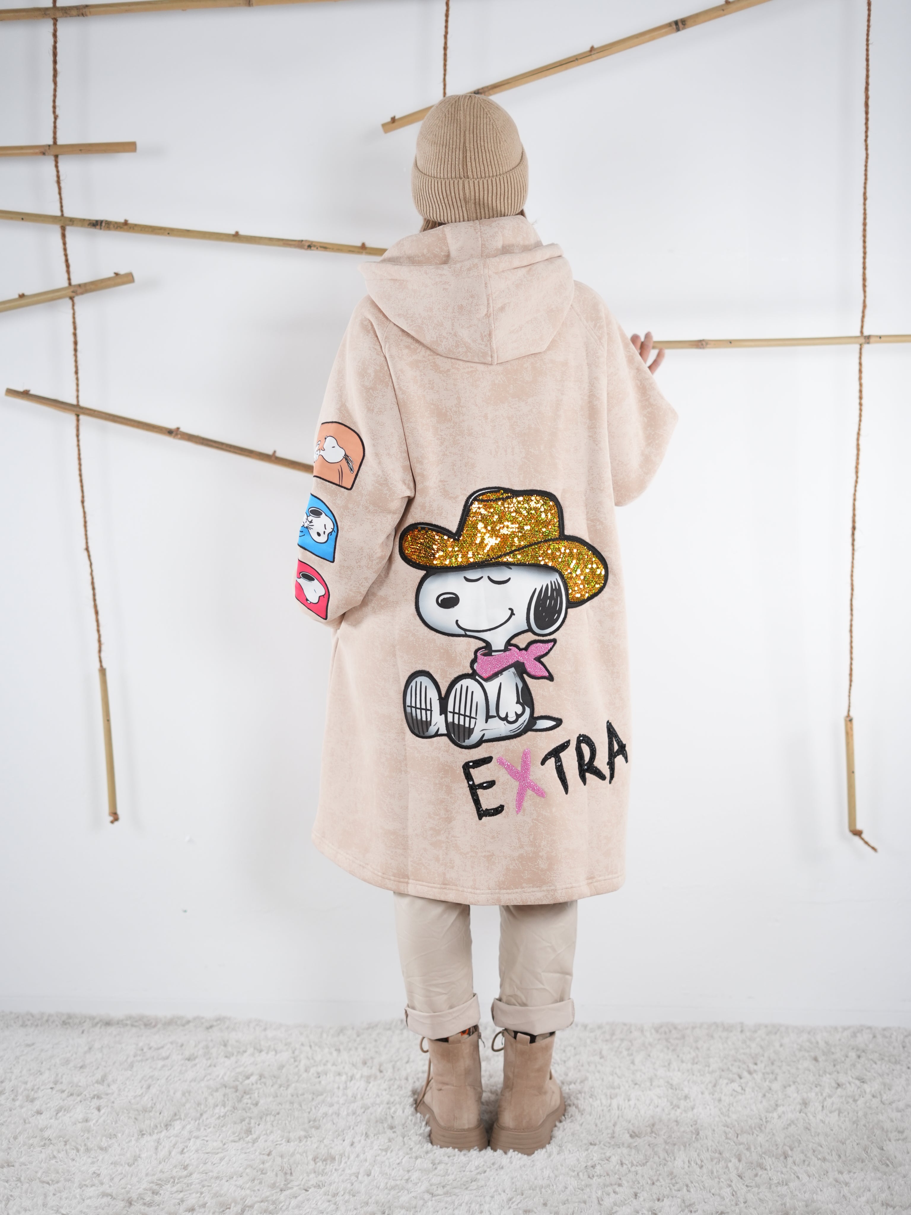 Rückansicht des beige Mantels mit großem glitzerndem Comic-Aufdruck