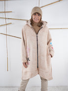 Mantel in Beige mit Kapuze und Frontzipper aus nächster Nähe