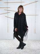 Frontansicht der schwarzen Tunika mit Glitzer und Tüll. Fokus liegt auf den Verzierungen aus Tüll. 