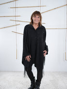 Nahaufnahme der Tunika in schwarz. Marion trägt die weit fallende Tunika lässig mit einer Leggin.