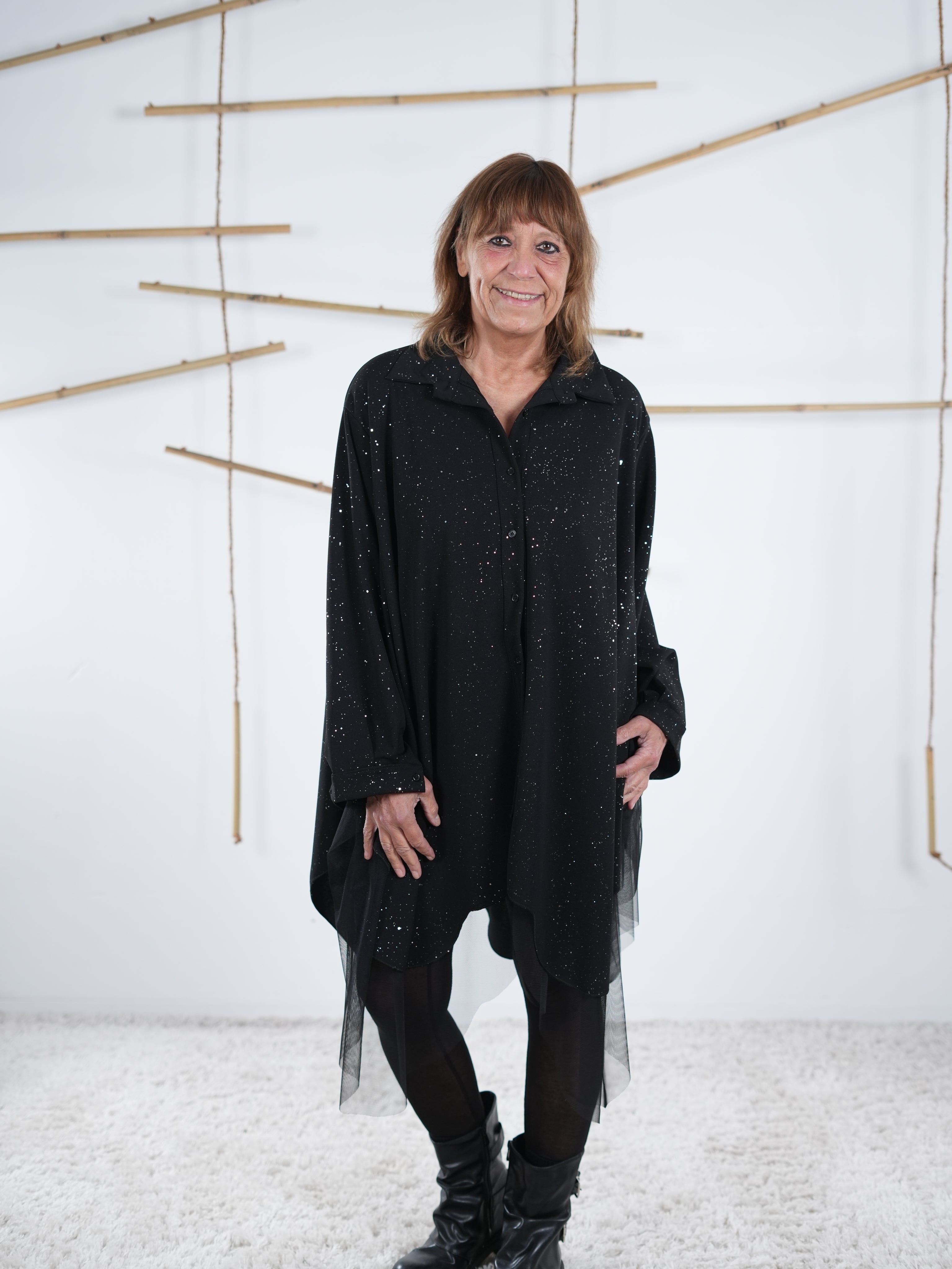 Nahaufnahme der Tunika in schwarz. Marion trägt die weit fallende Tunika lässig mit einer Leggin.
