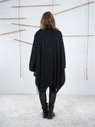 Rückenansicht der Tunika in schwarz. Die glitzernden Details funkeln. 