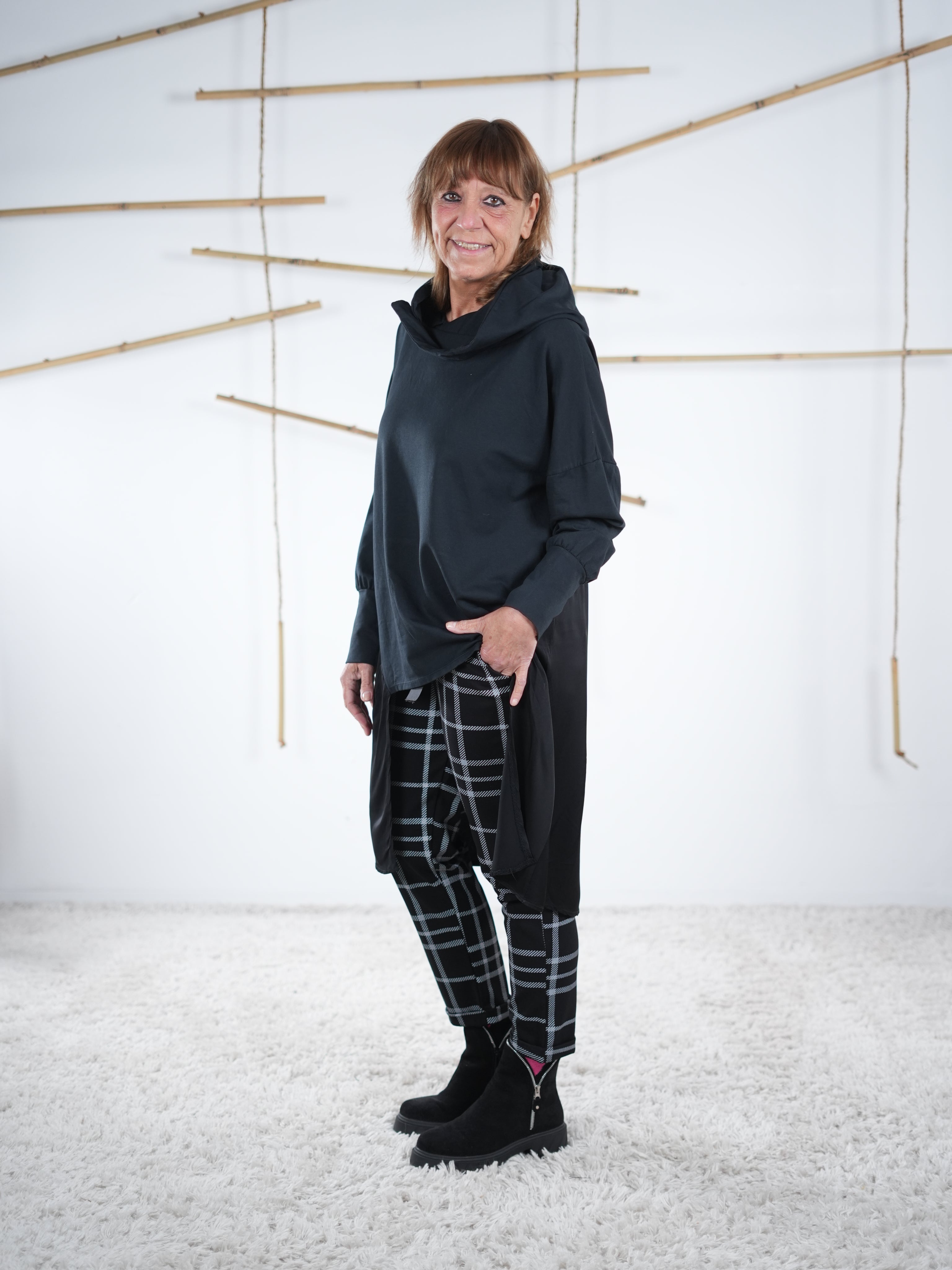 Seitliche Ansicht der langen schwarzen Tunika mit Satin-Einsatz, Einheitsgröße, lässiger Oversize-Look.