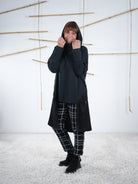 Schwarze Damen-Tunika mit Kapuze und Satin-Einsatz, getragen mit hochgezogener Kapuze.