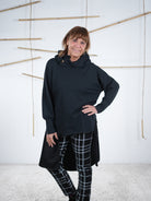 Schwarze modische Tunika mit seitlichem Satin-Stoff und Kapuze, feminine Vorderansicht.